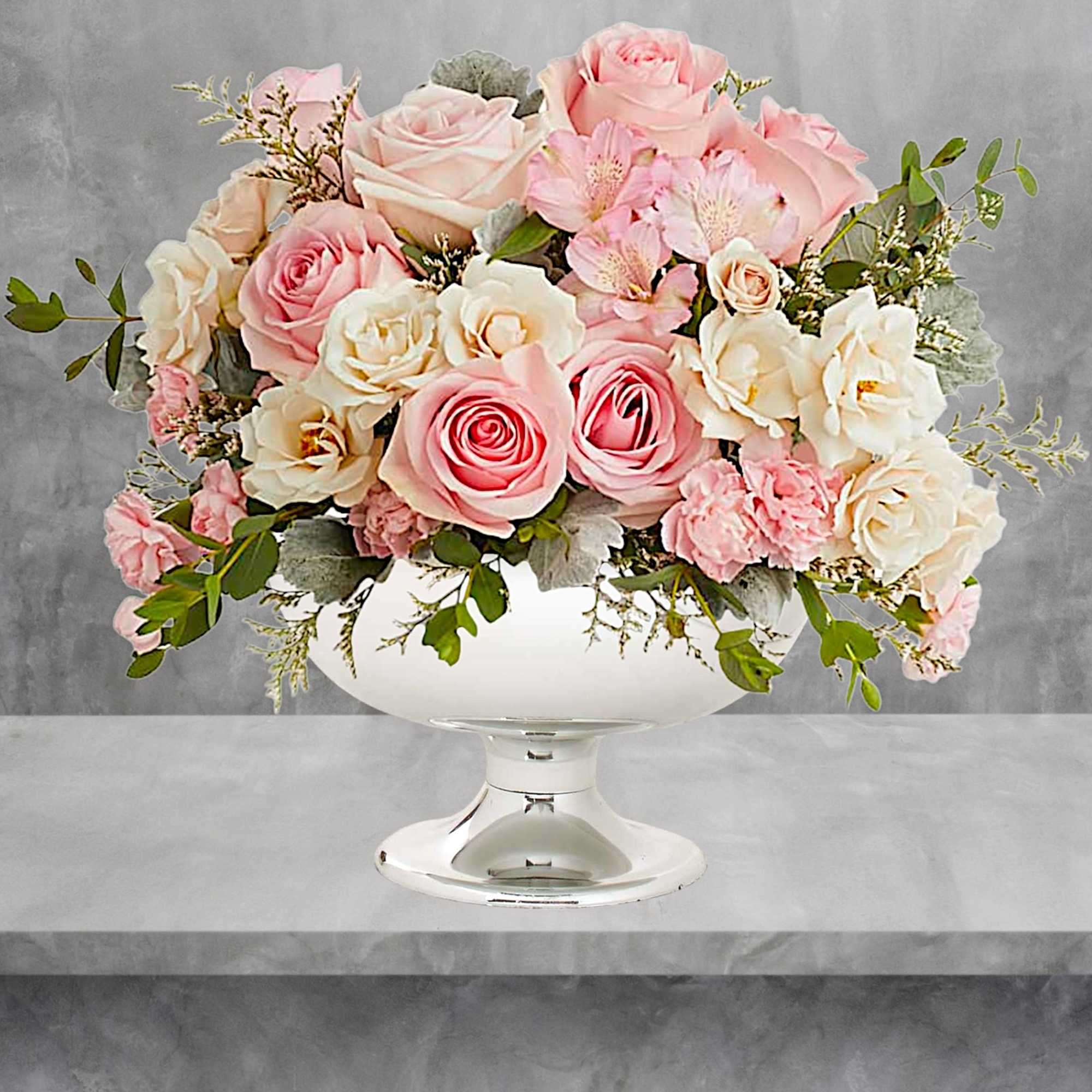 Illuminate love with embracing soft pastel shimmer and cradling an exquisite arrangement
