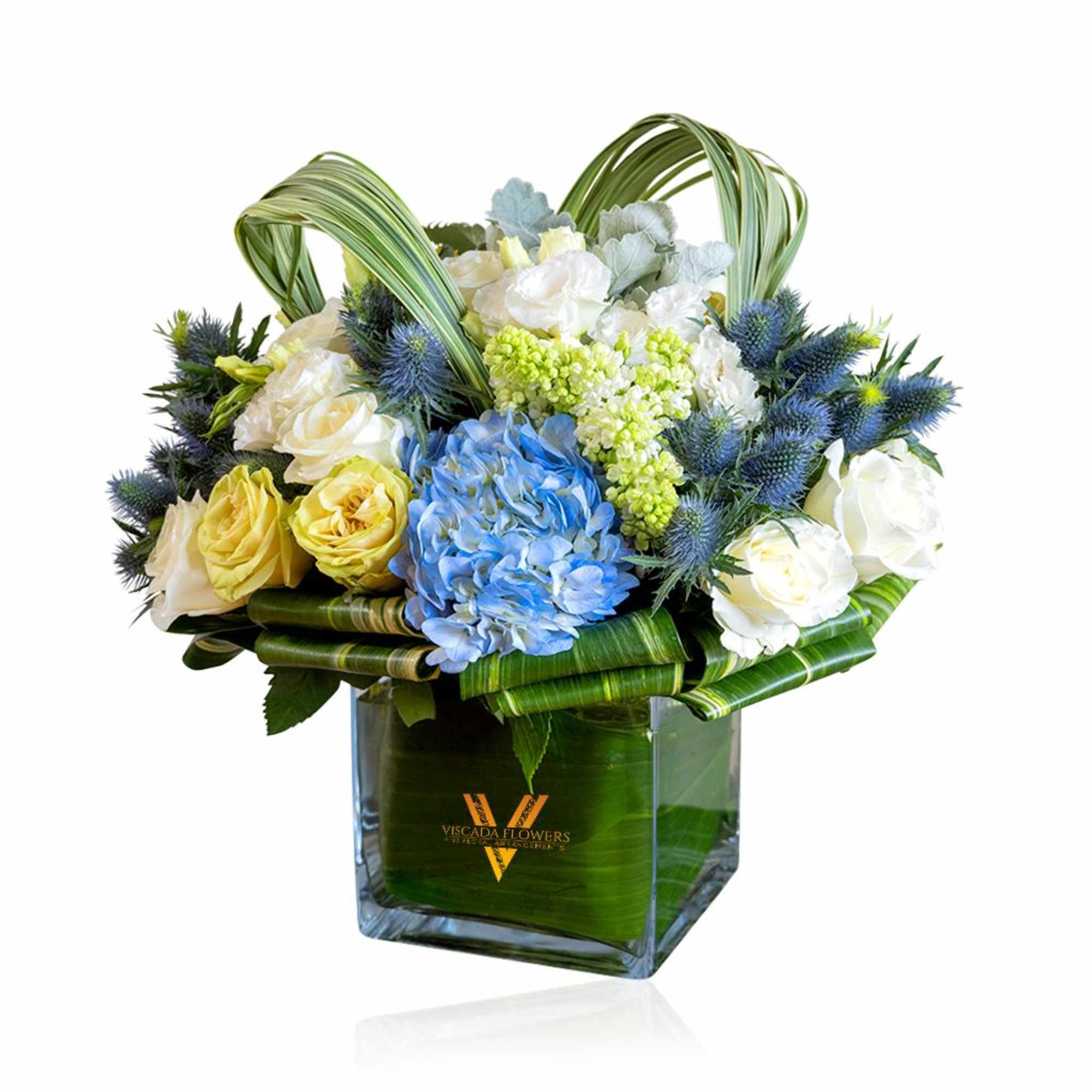 This captivating bouquet combines blue hydrangeas, white tulips, blue sea holly, and