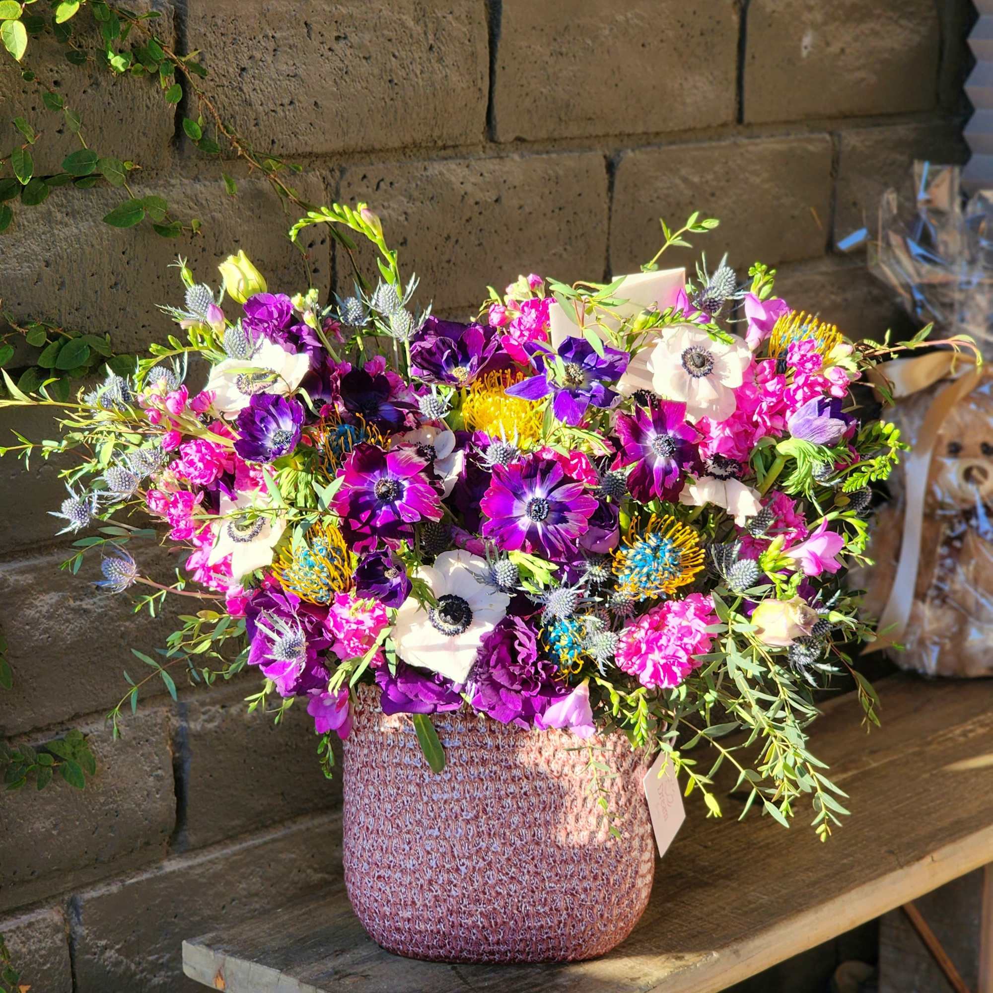 This stunning arrangement combines vibrant fresh greens with delicate white and purple