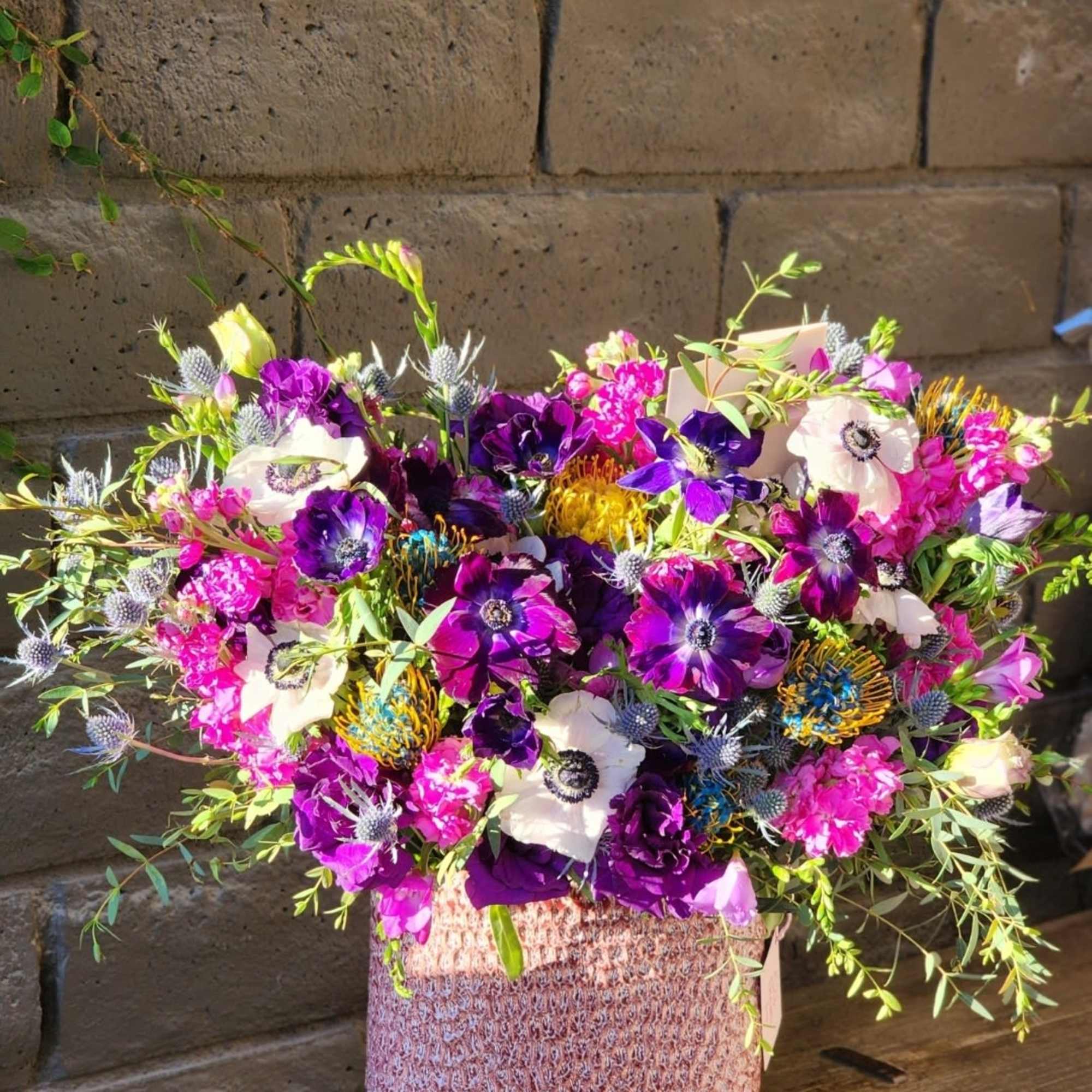 This stunning arrangement combines vibrant fresh greens with delicate white and purple