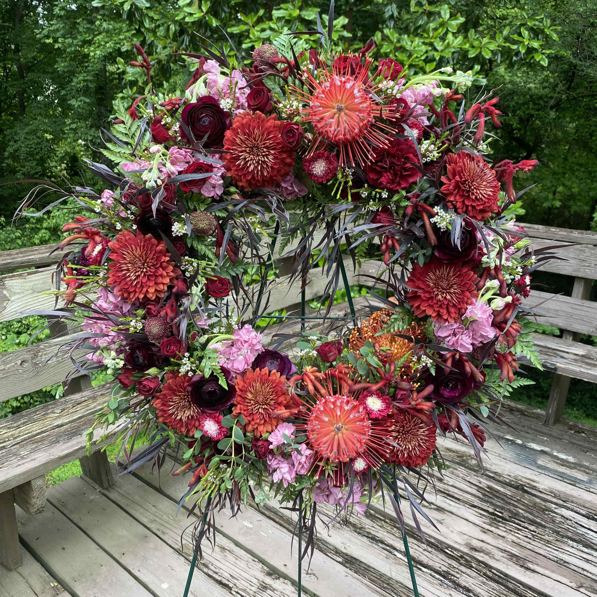 Dramatic funeral spray or wreath with a variety of flowers. Flexible color