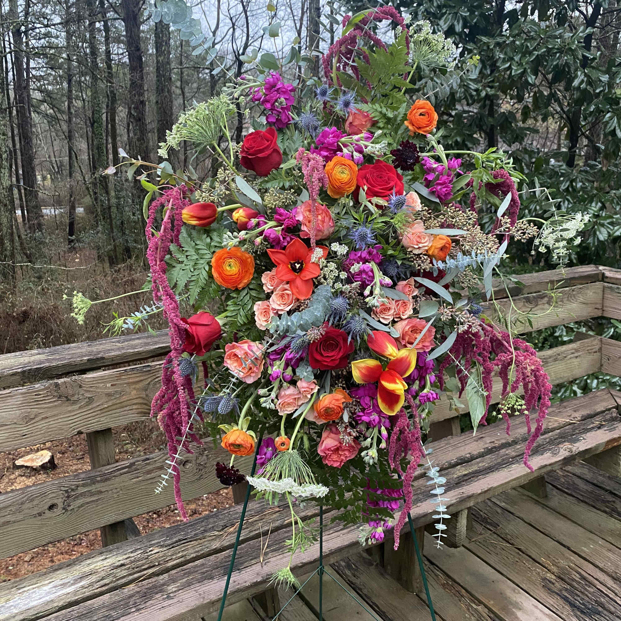 Dramatic funeral spray or wreath with a variety of flowers. Flexible color