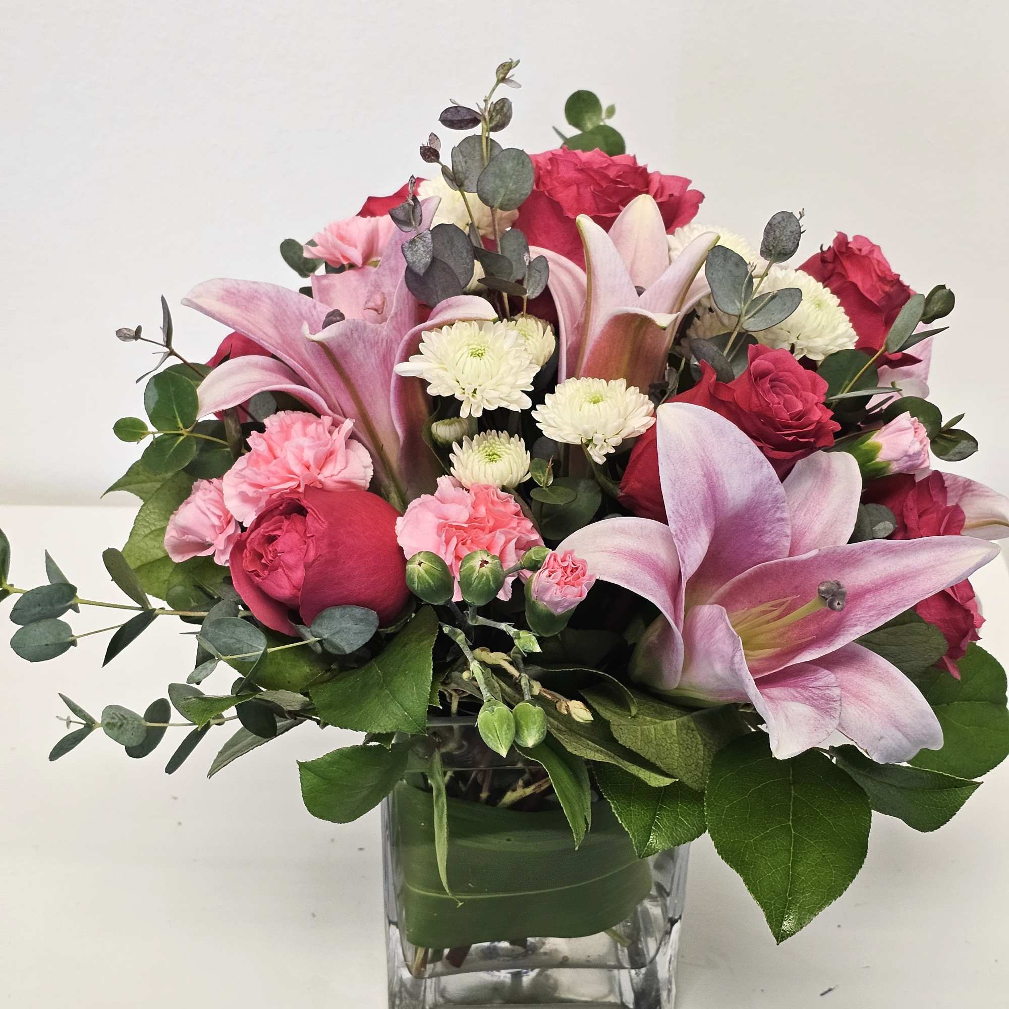 All arranged in a clear, elegant glass vase, this bouquet blends rich