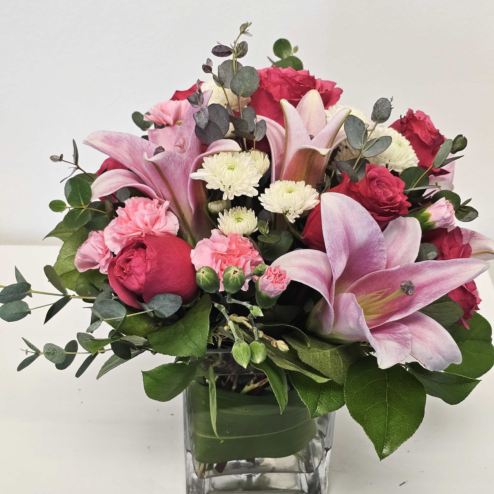 All arranged in a clear, elegant glass vase, this bouquet blends rich