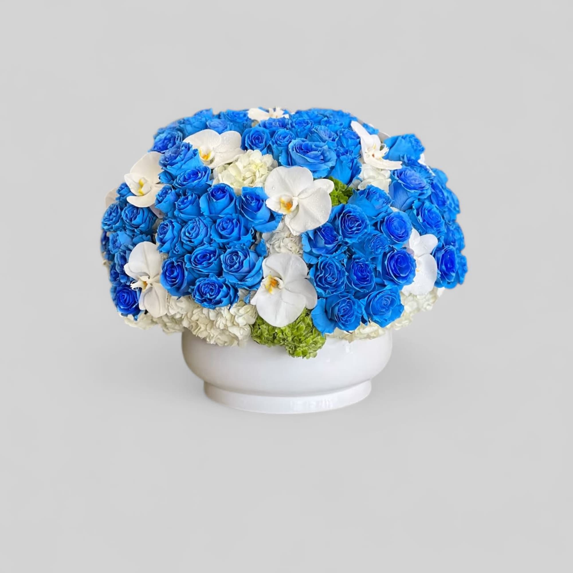 Blue rose clusters with white orchids.