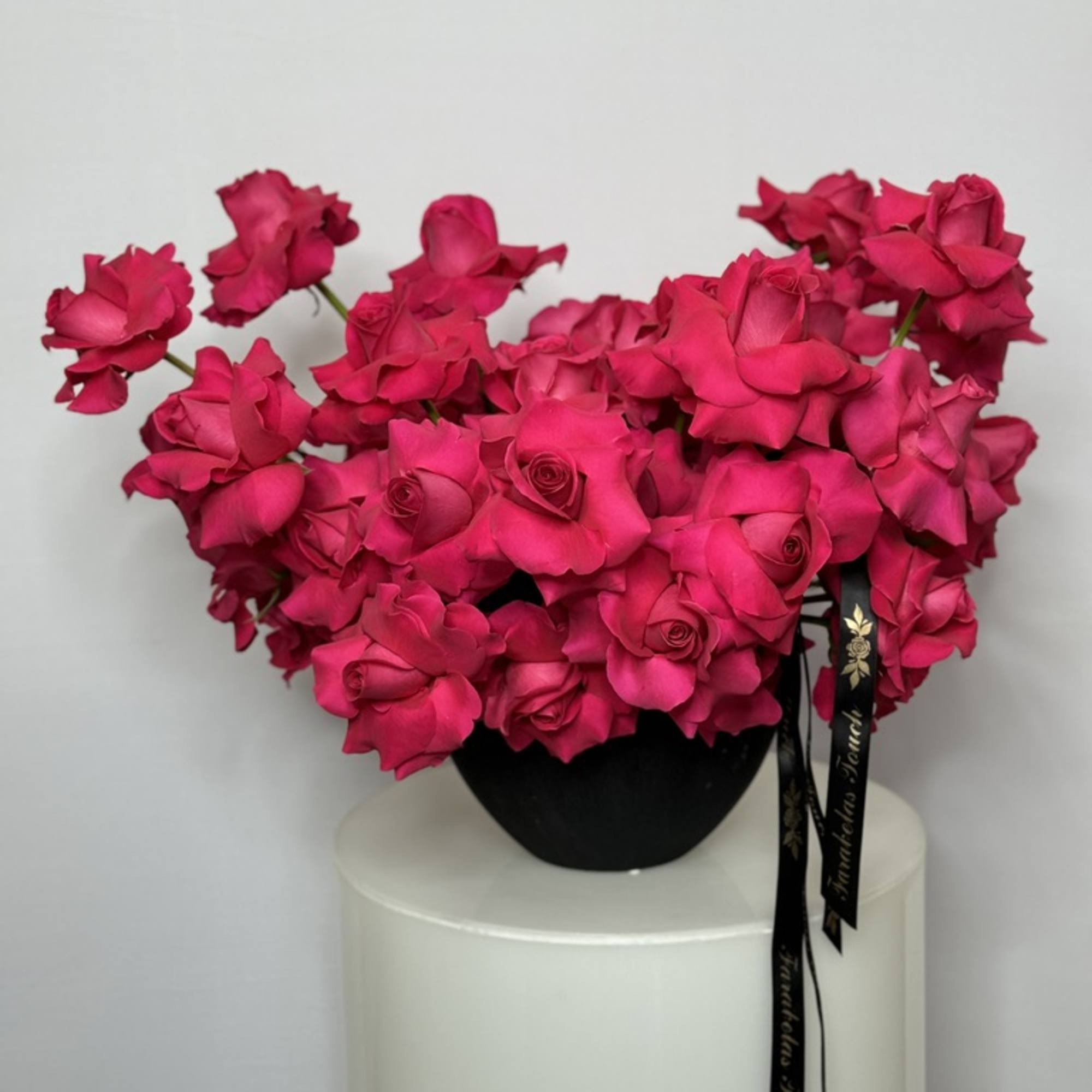 The modern style arrangement in the black vase is an exquisite display
