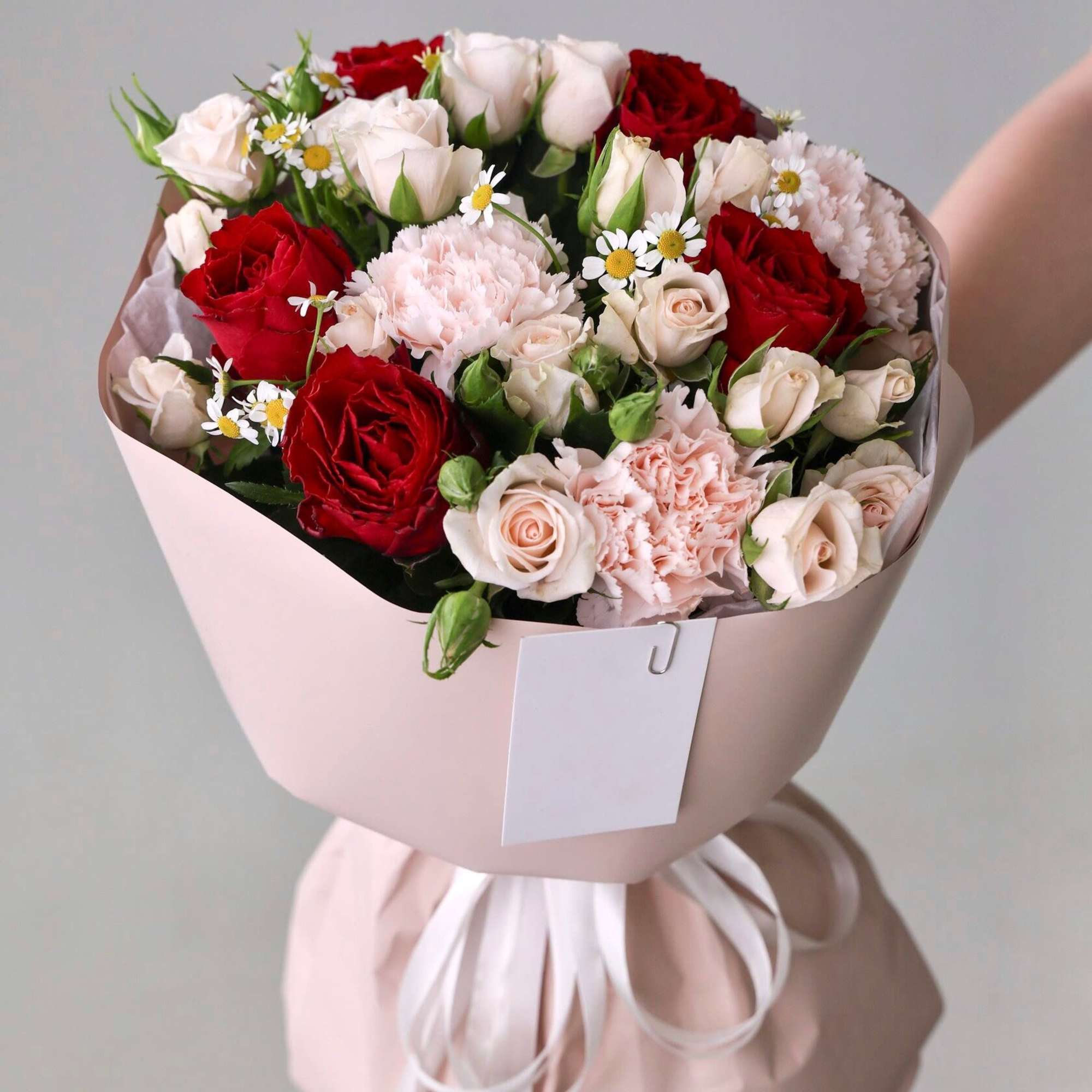 Bouquet of red roses, pink mini roses and dianthus.