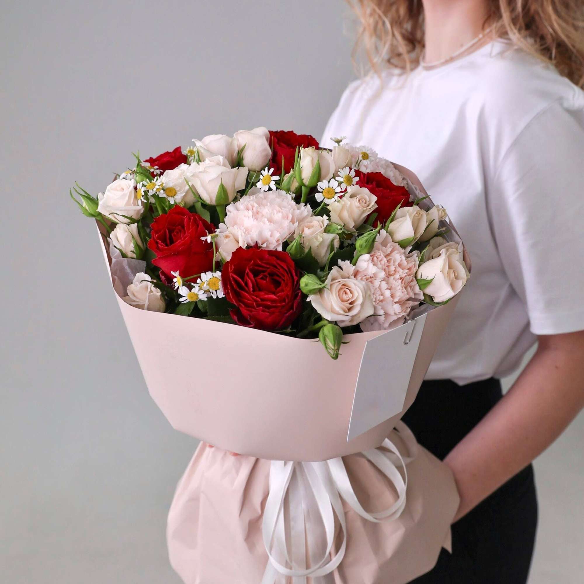Bouquet of red roses, pink mini roses and dianthus.