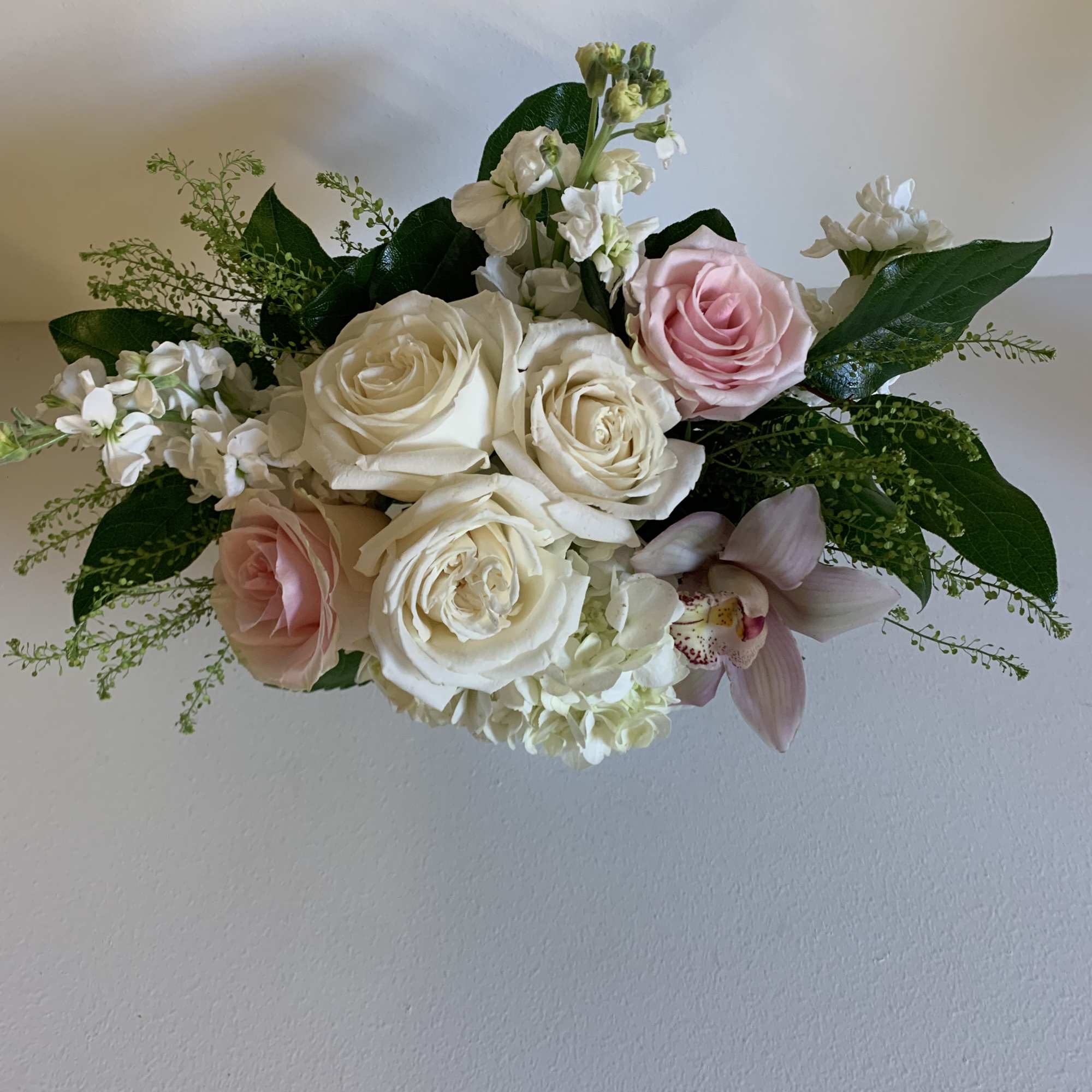 A soft mix of white roses, white hydrangea, and white stock mixed