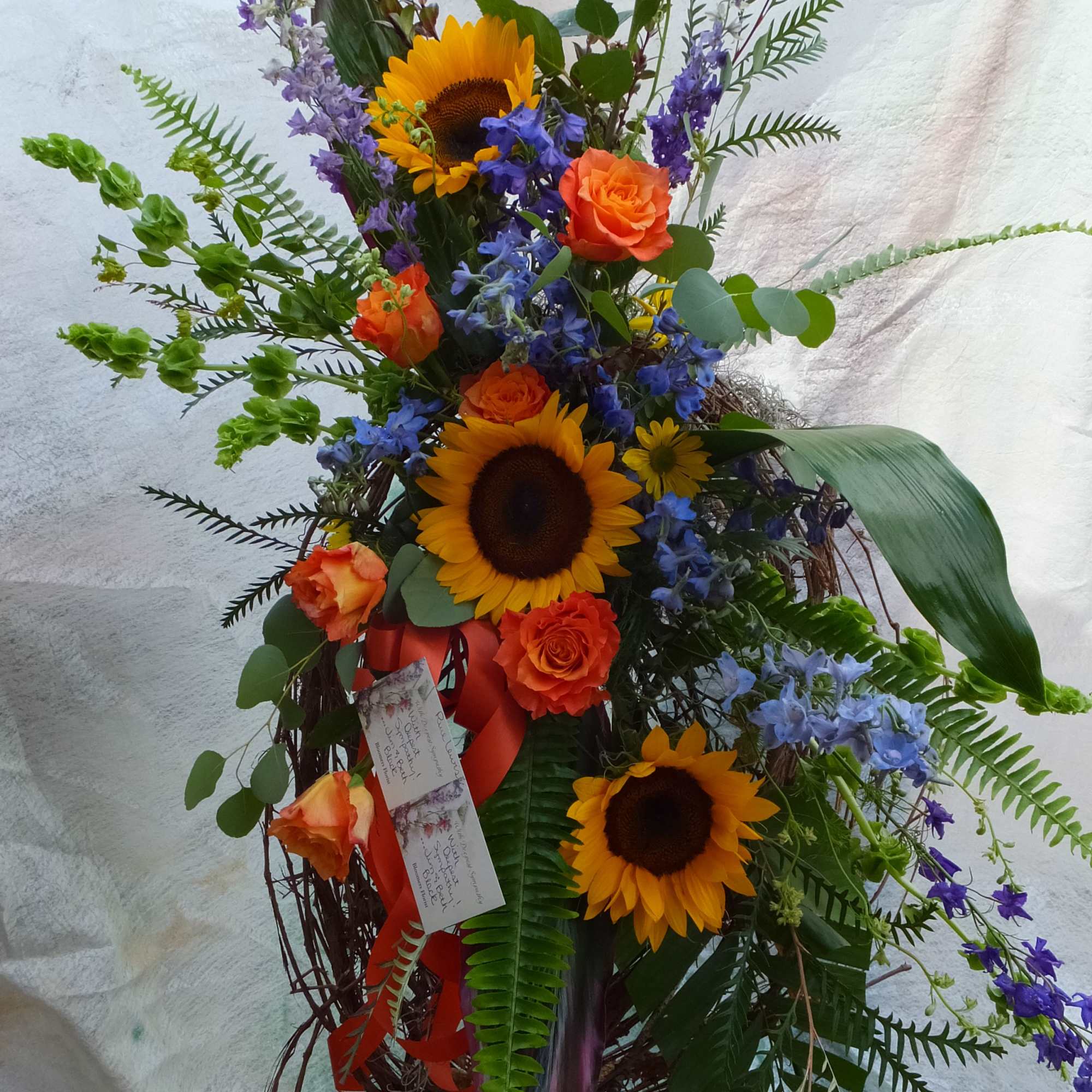 A grapevine wreath with a beautiful array of bright, bold, flowers. The