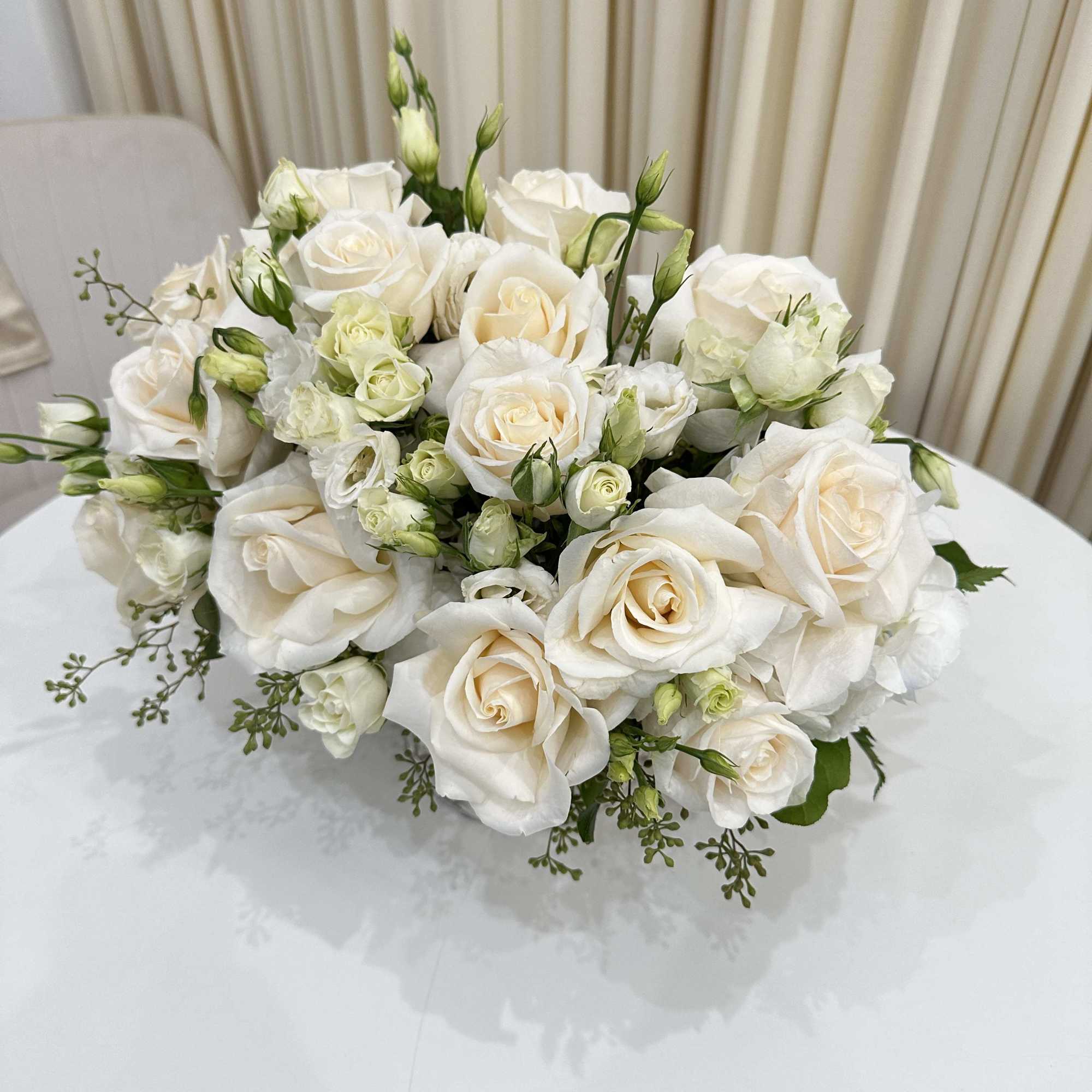 This elegant sympathy arrangement features a stunning white flower arrangement delicately arranged