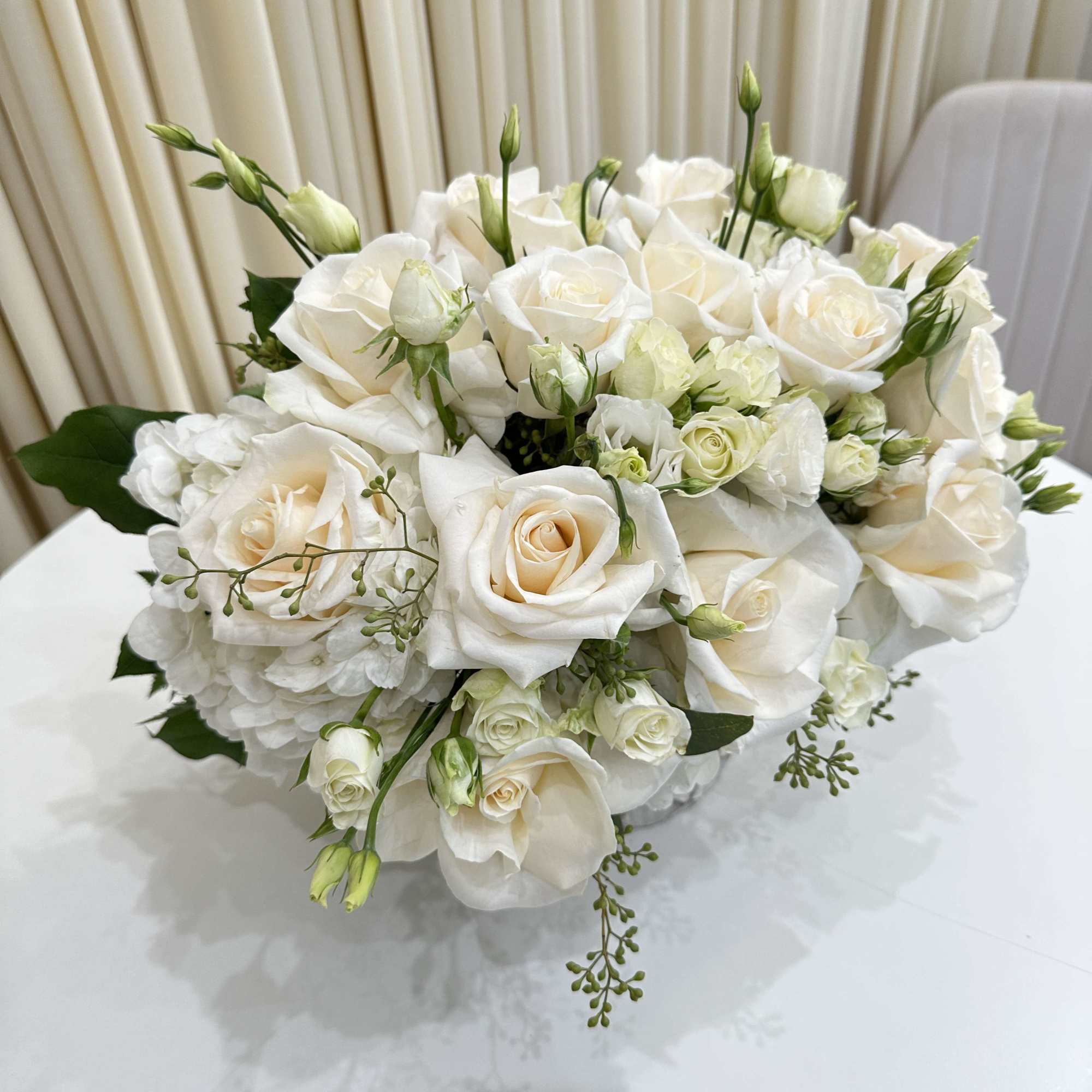 This elegant sympathy arrangement features a stunning white flower arrangement delicately arranged