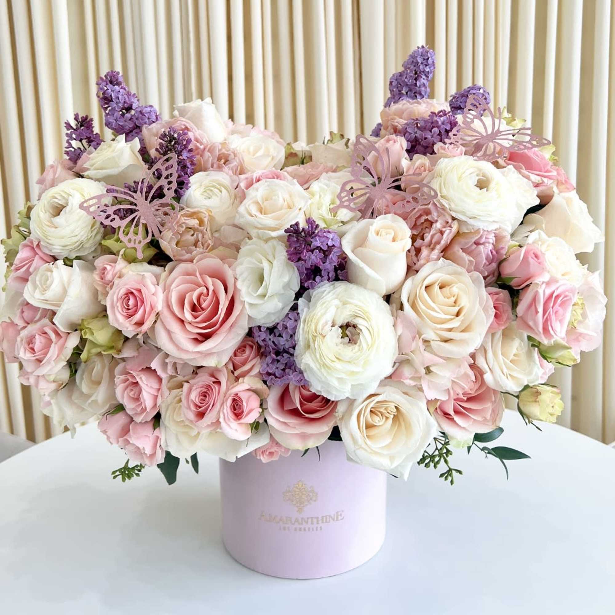 This beautiful flower arrangement features a mix of pink, purple, and white