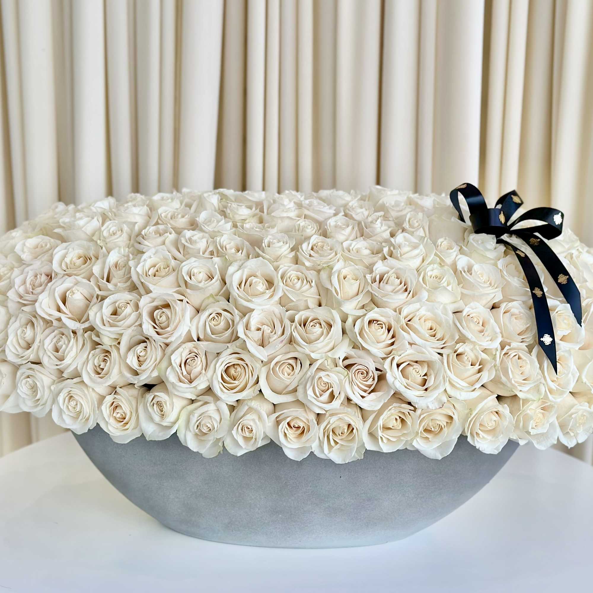 Experience the enchanting allure of our &quot;Whispering Petals&quot; White Rose Arrangement. Delicate