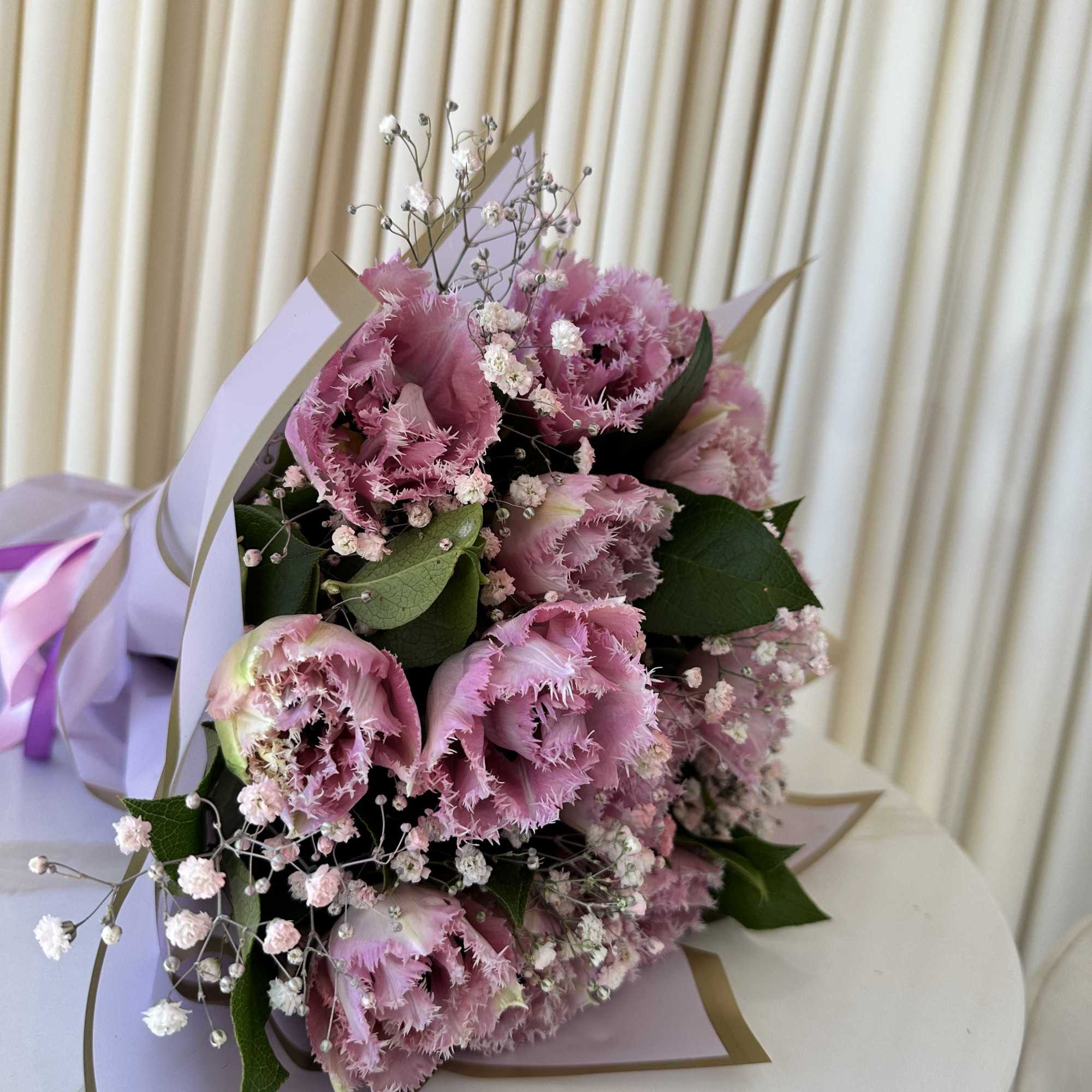 Woven with a captivating mix of deep purple tulips, this enchanting bouquet