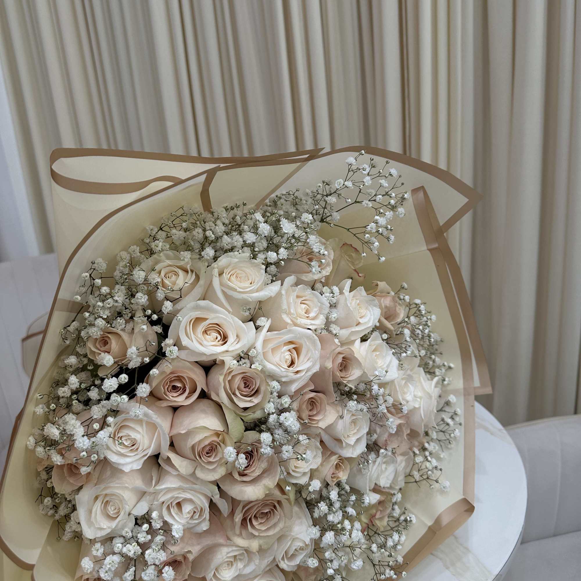 This delicate bouquet features 50 roses with soft baby&#039;s breath accents. The