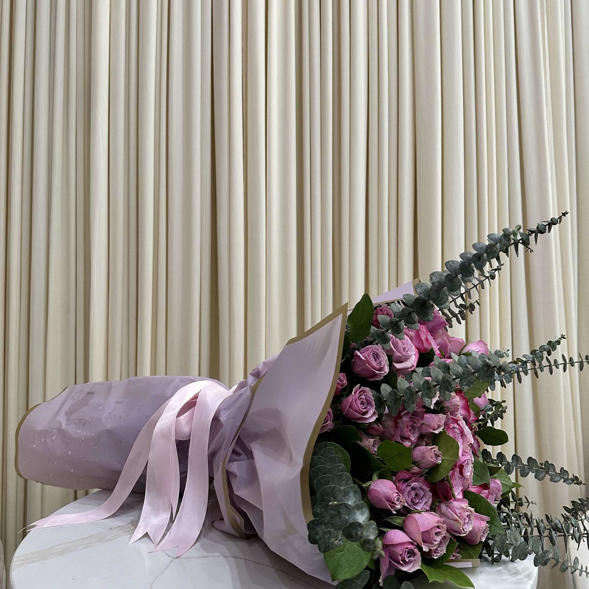 This whimsical bouquet features a cascade of purple roses, baby purple roses