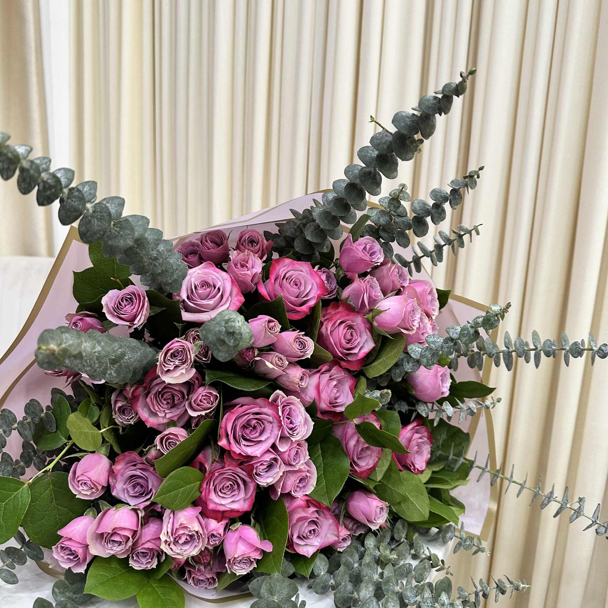 This whimsical bouquet features a cascade of purple roses, baby purple roses