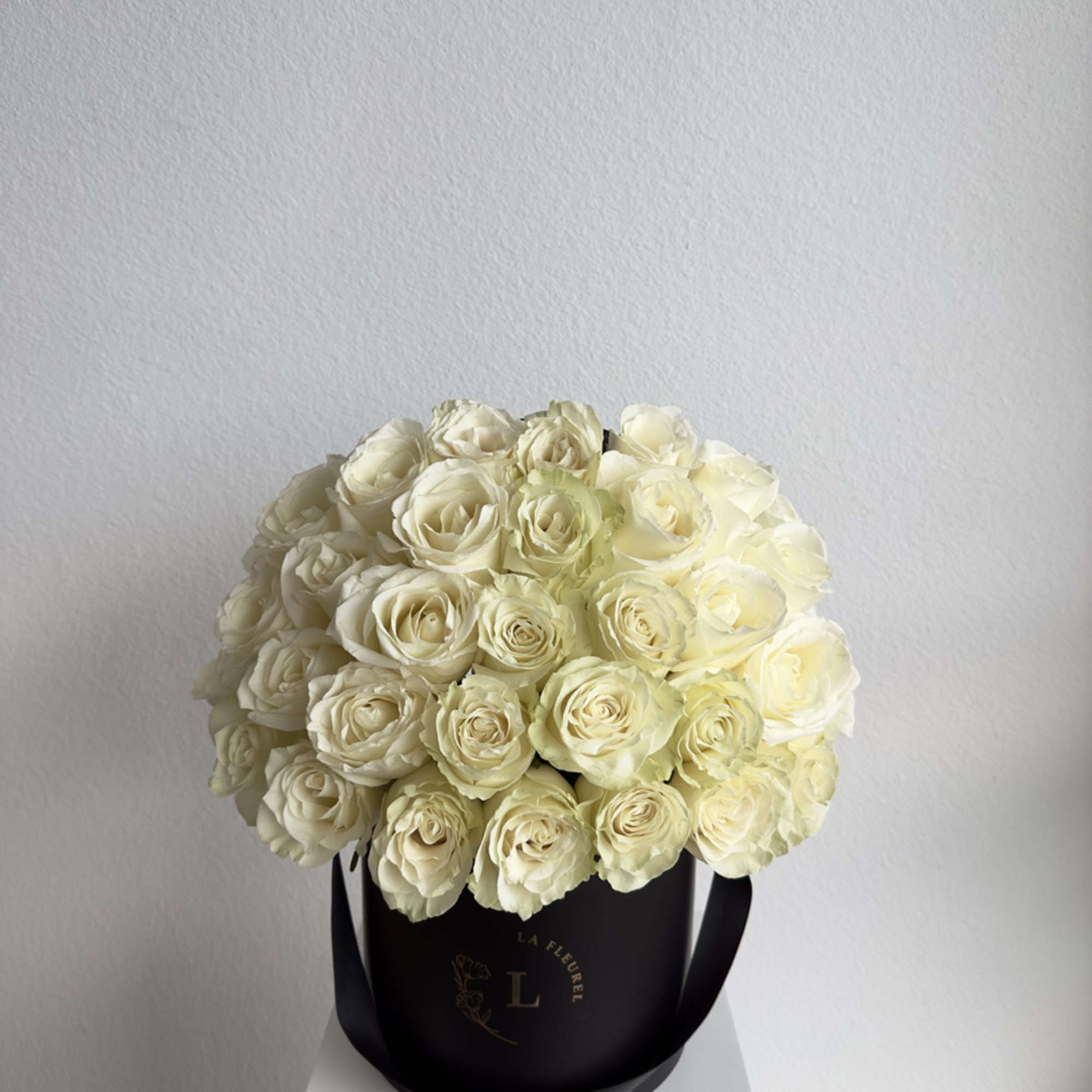 This beautiful arrangement filled with white roses and greens to deliver your