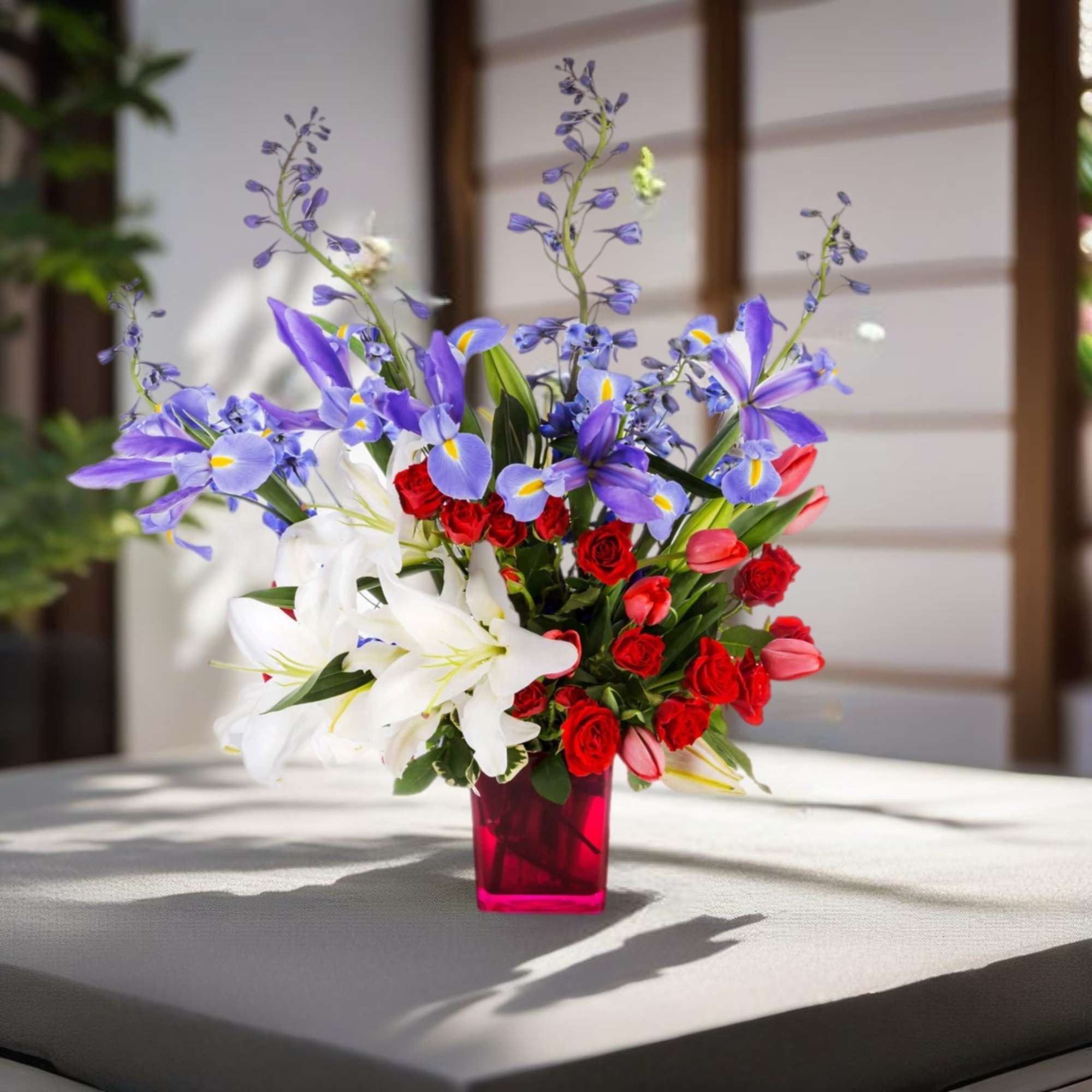 You are a firework! This arrangement featuring iris, tulips, and lilies is