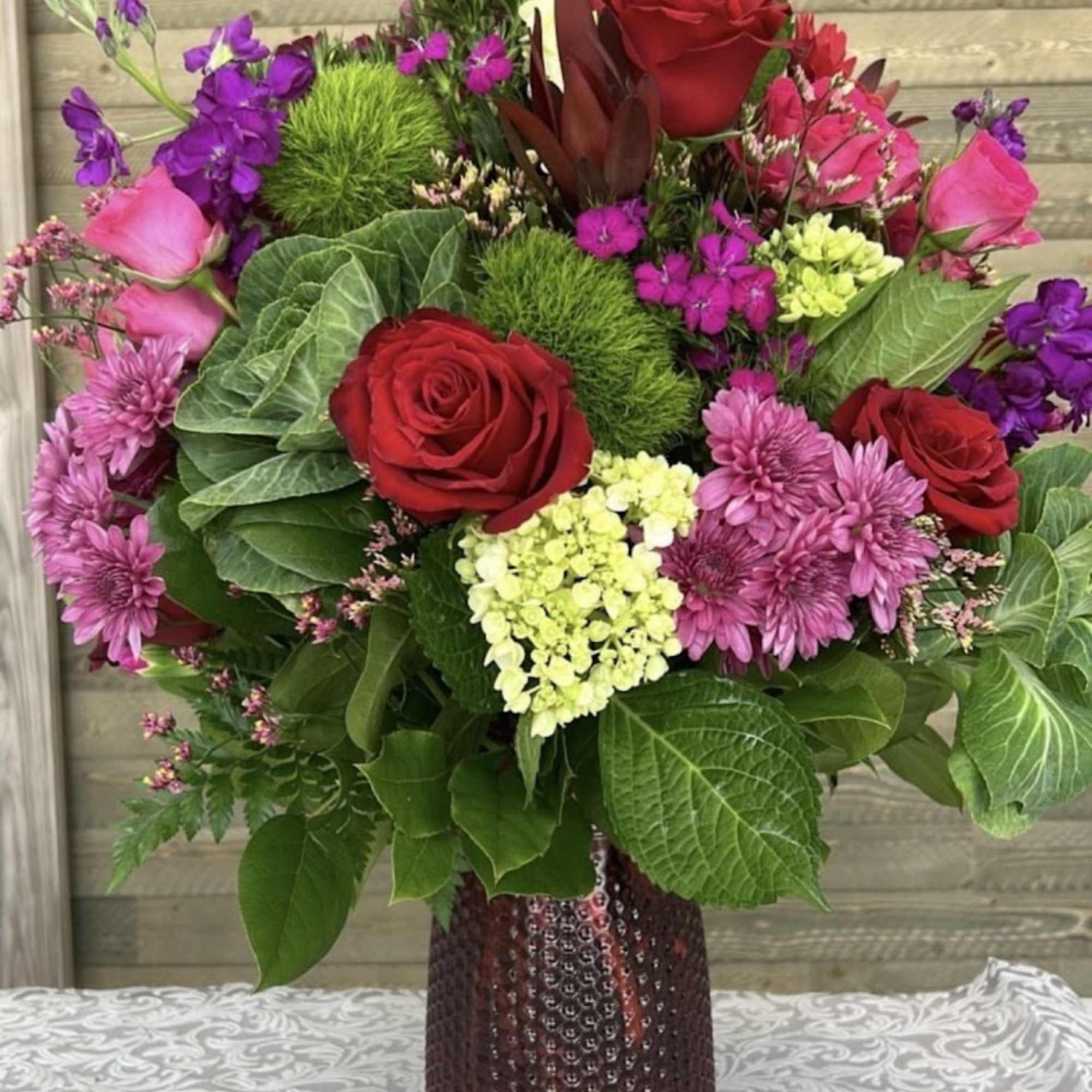 This exquisite bouquet features a harmonious blend of delicate roses and lush