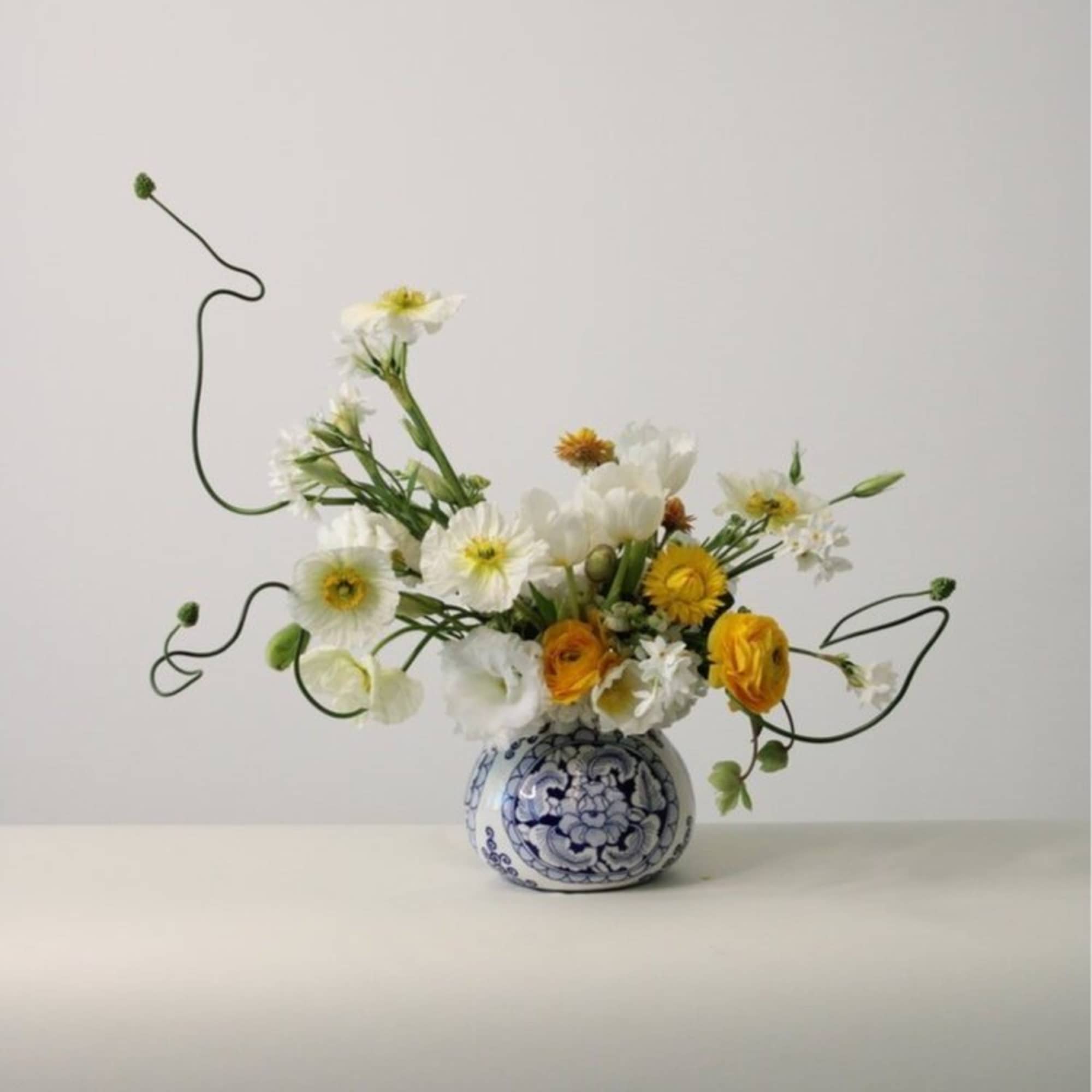 - Whimsical flower arrangement in airy whites, yellows, and greens
- Bright and