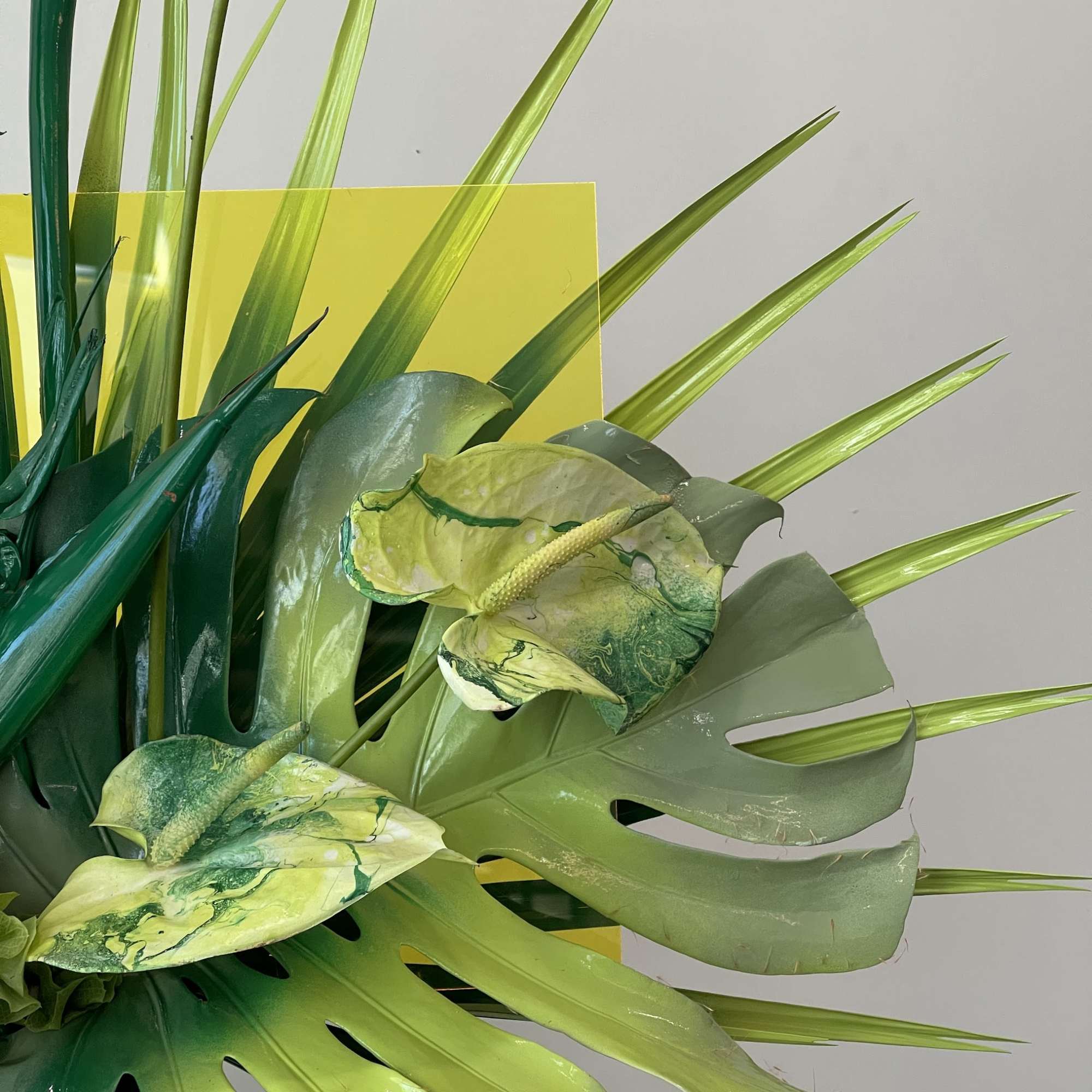 - Tall, striking arrangement with lush green foliage
- Bold spray-painted green leaves