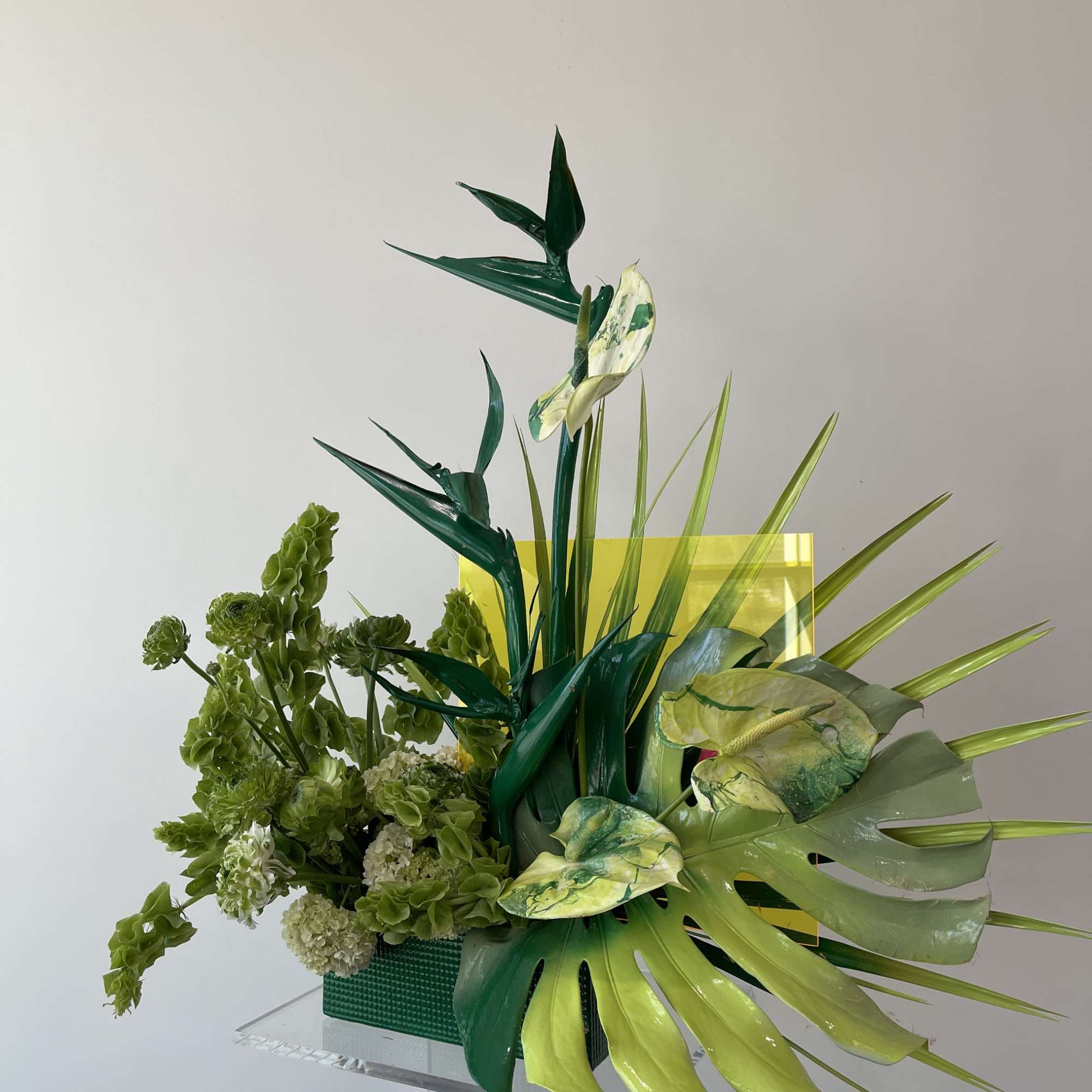 - Tall, striking arrangement with lush green foliage
- Bold spray-painted green leaves