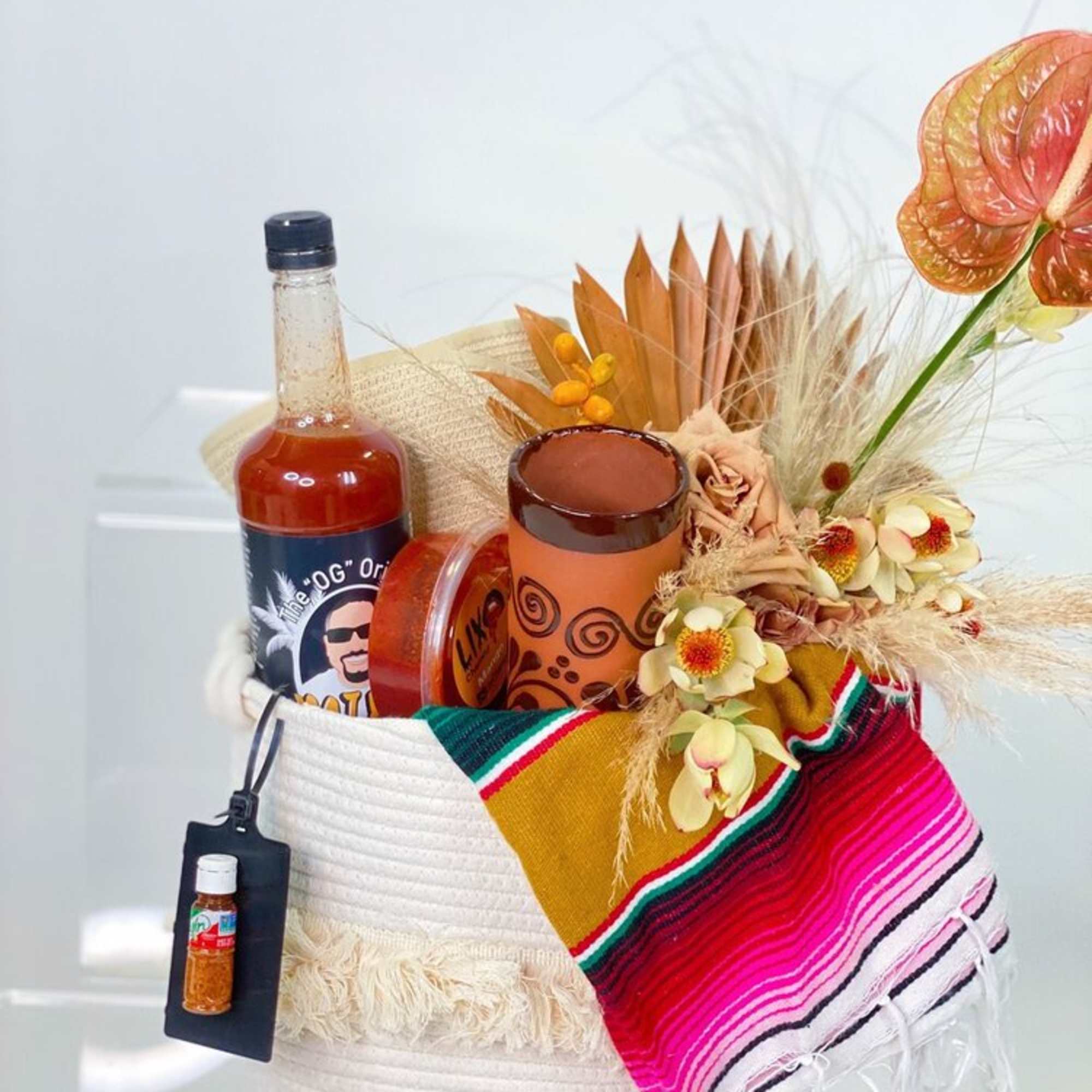 - OFF-WHITE WOVEN TOTE
- DESERT CLAY TONED FLORAL ARRANGEMENT
- CREAM SOMBRERO
- SERAPE