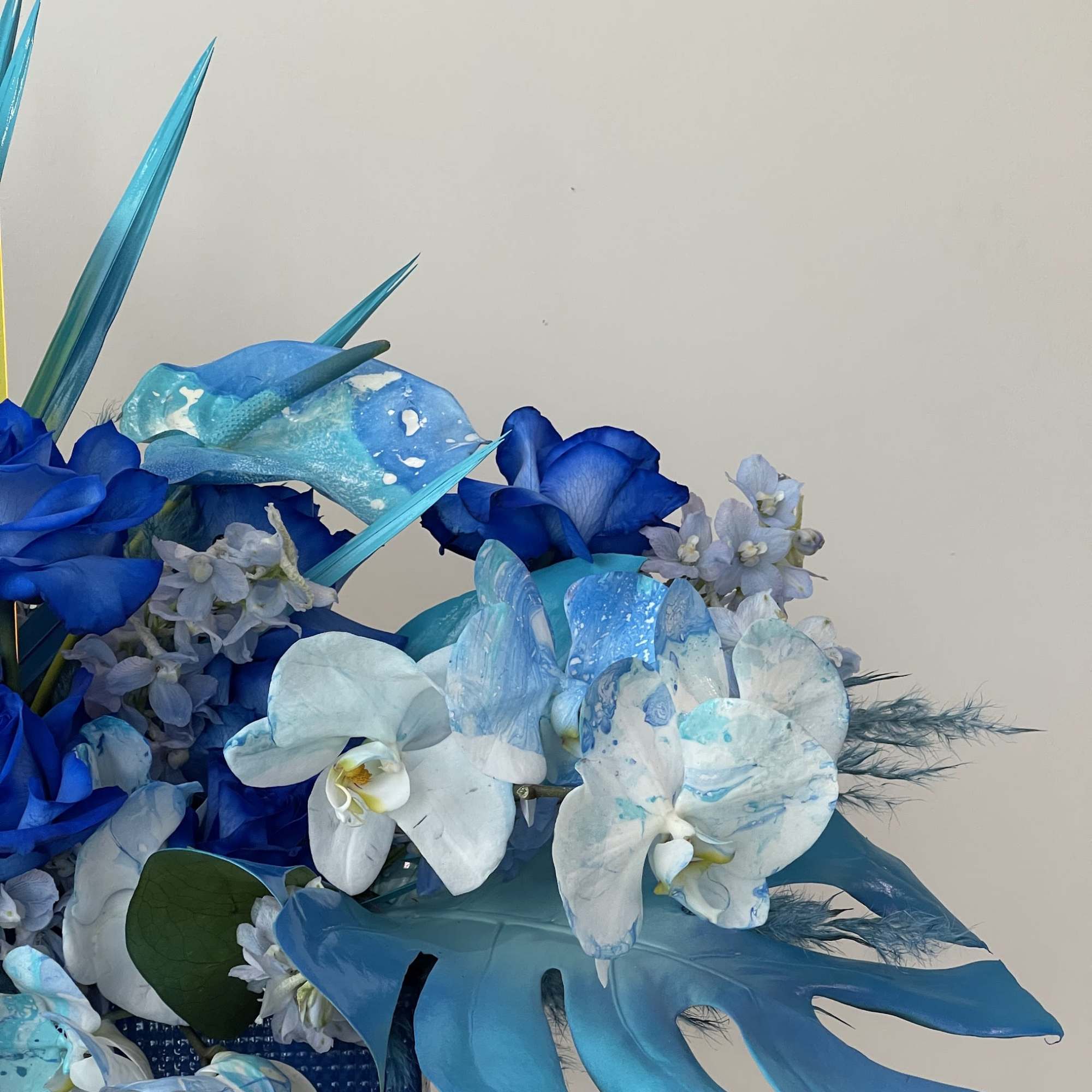 - Monochromatic blue blooms
- Crisp white spray-painted leaves for contrast
- Elegant, fresh