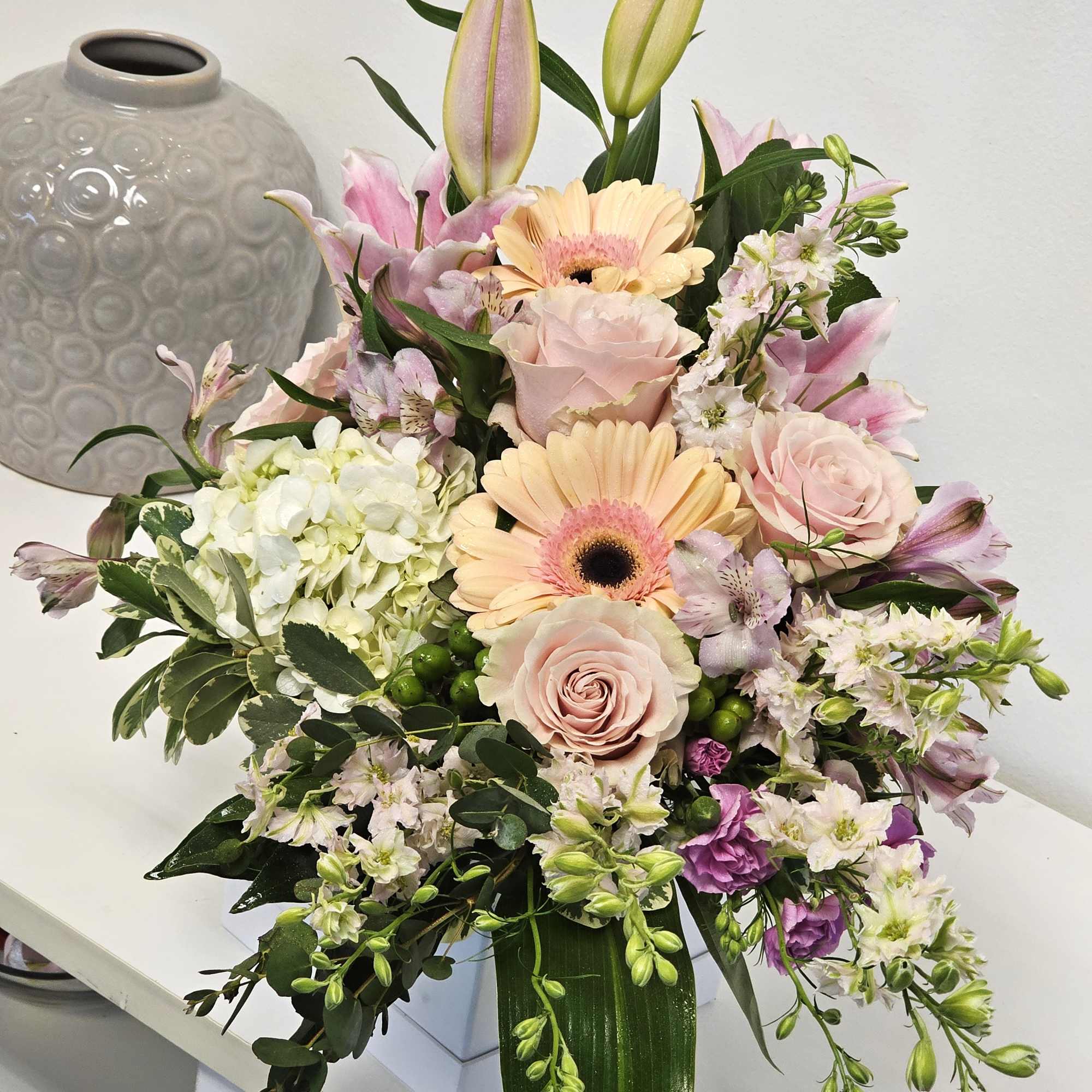 Our Delicate Sympathy Arrangement gracefully combines soft, pastel blooms, offering a gentle