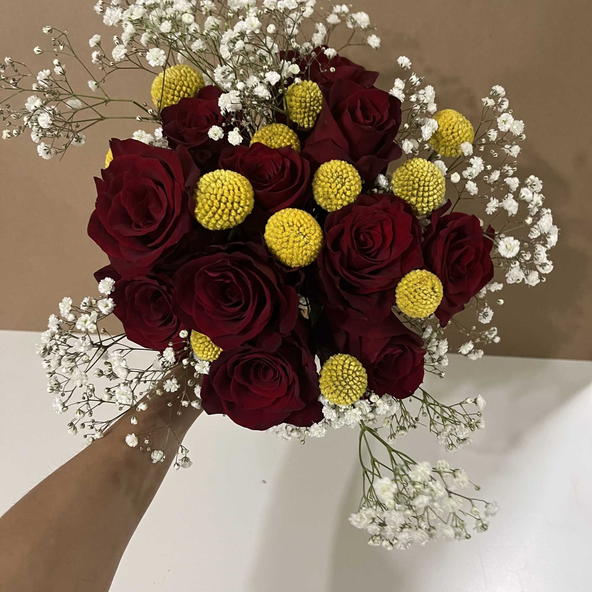 This bouquet features red roses paired with baby breath flowers and Sun