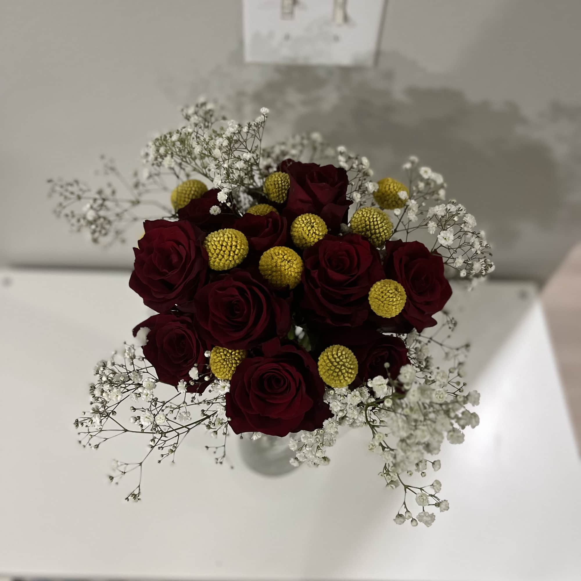 This bouquet features red roses paired with baby breath flowers and Sun