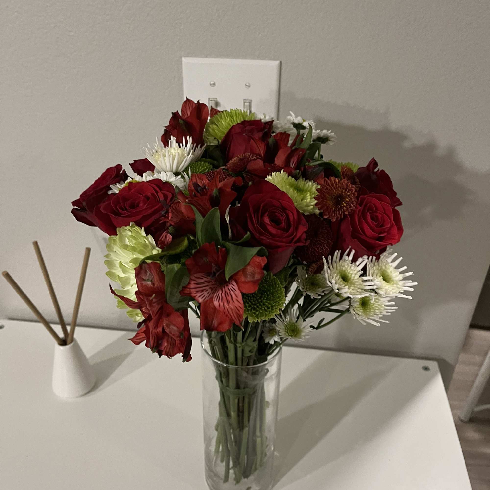 This bouquet features red roses paired with bunch mums and spider mums.