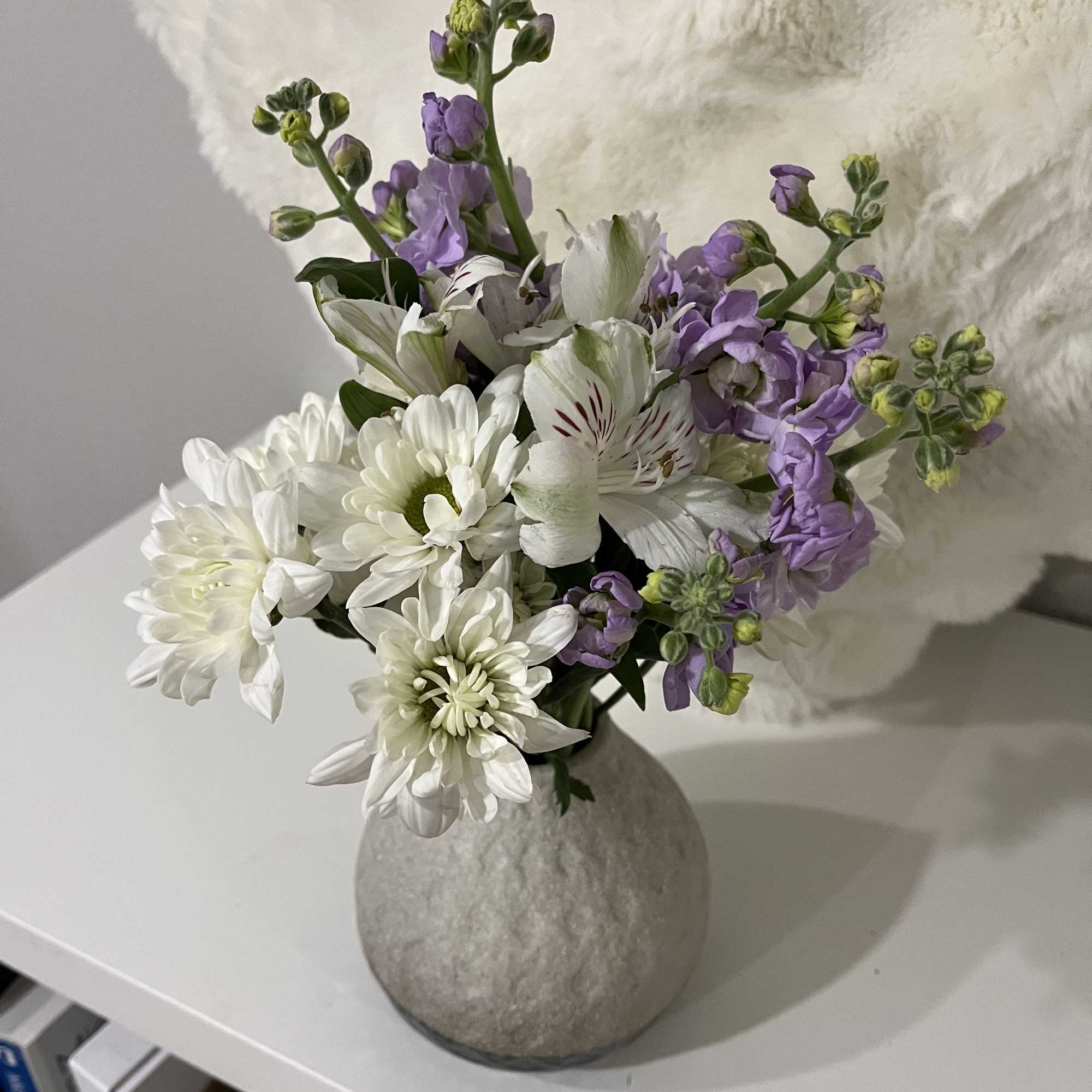 This mini bouquet features chrysanthemums (mums) paired with purple masa. It is