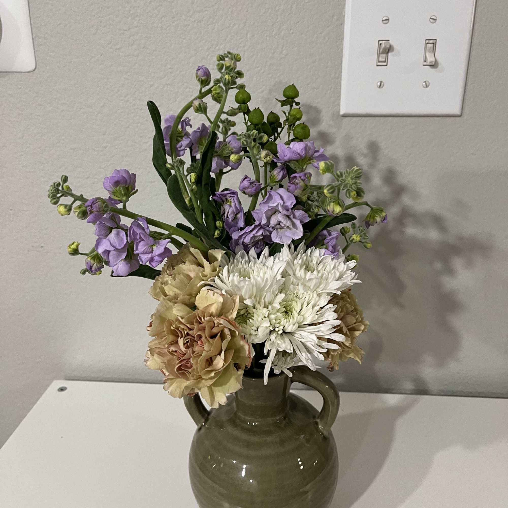 This mini bouquet features chrysanthemums (mums) paired with marigolds and mesa flowers.