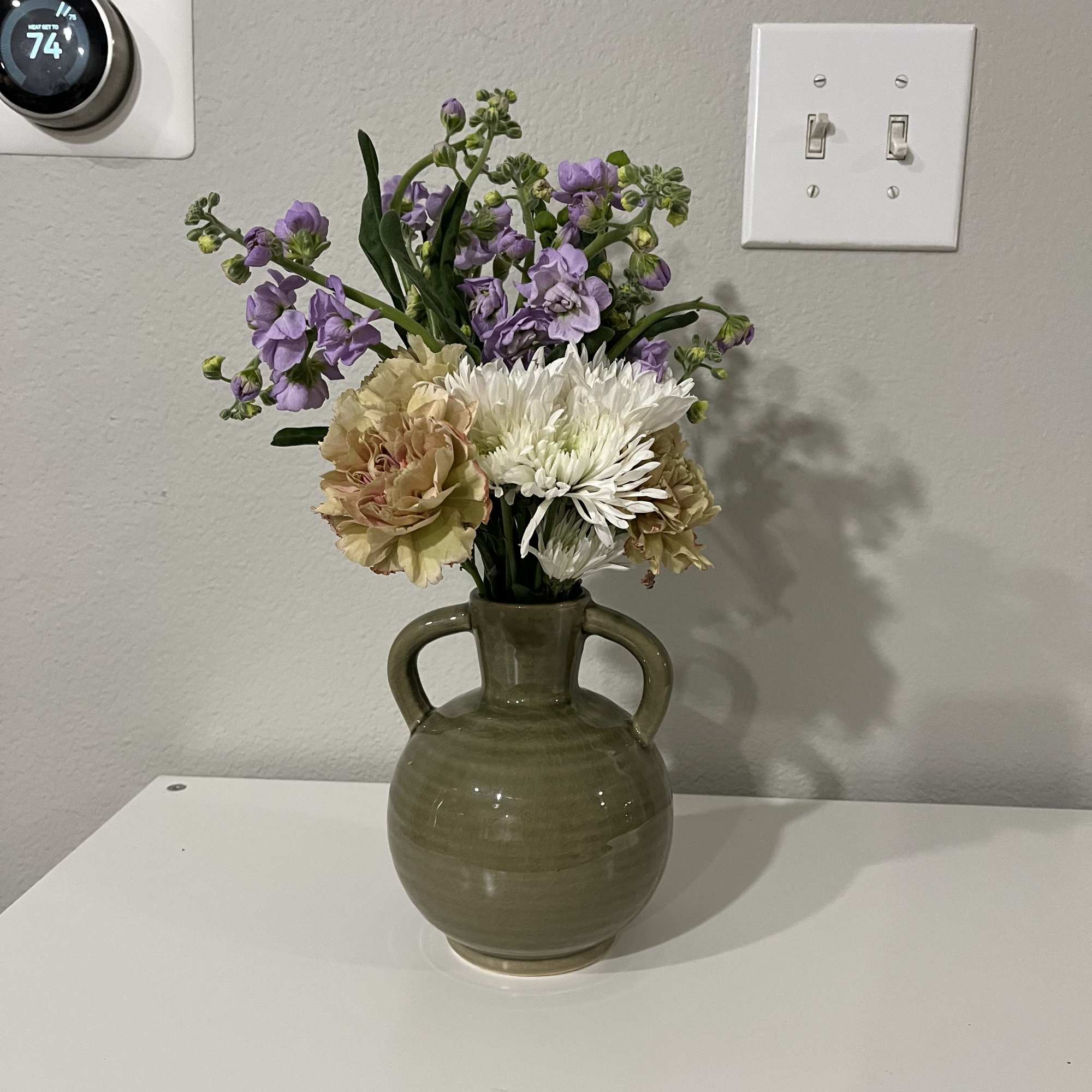 This mini bouquet features chrysanthemums (mums) paired with marigolds and mesa flowers.