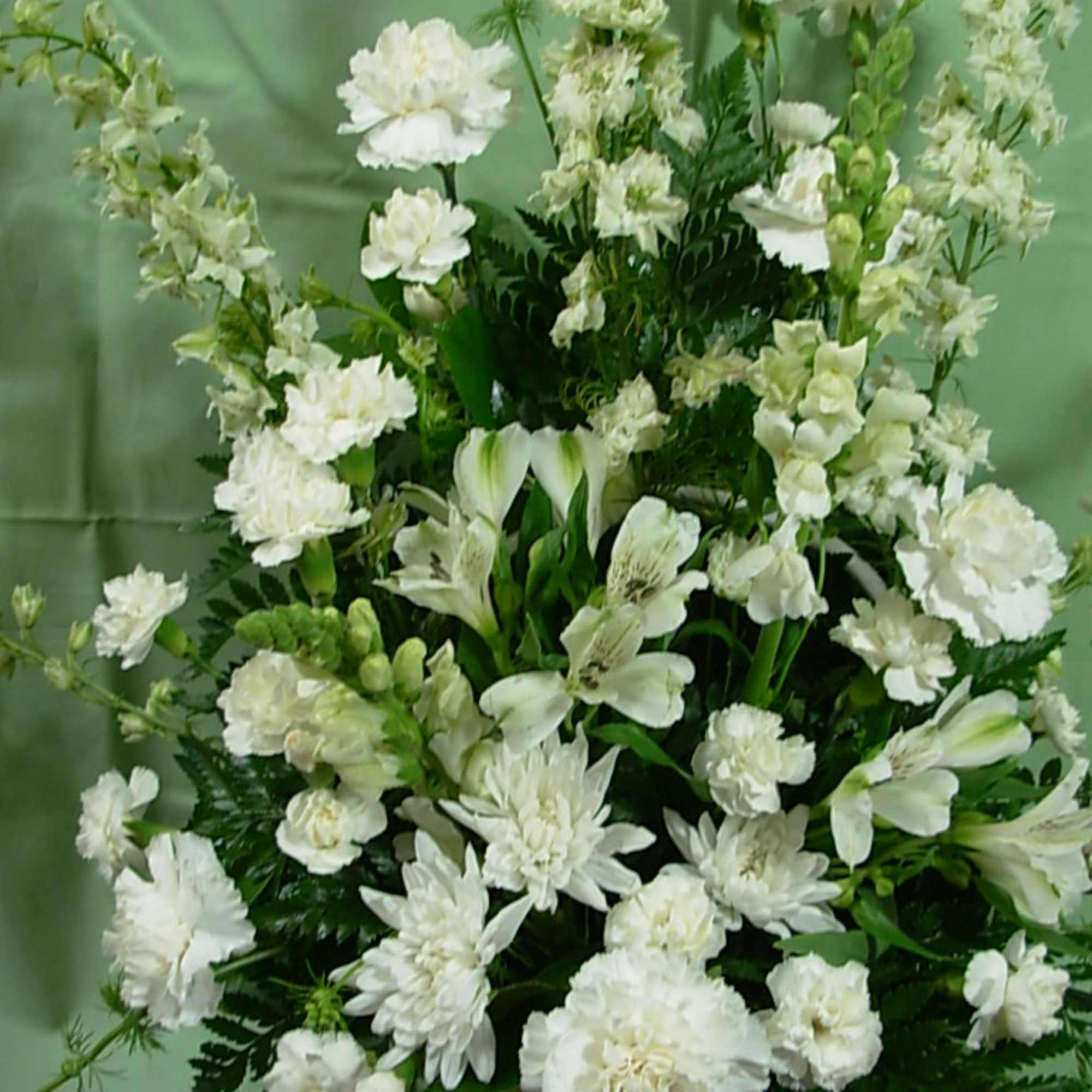 Our ETERNAL SYMPATHY arrangement is made in a white wicker basket with