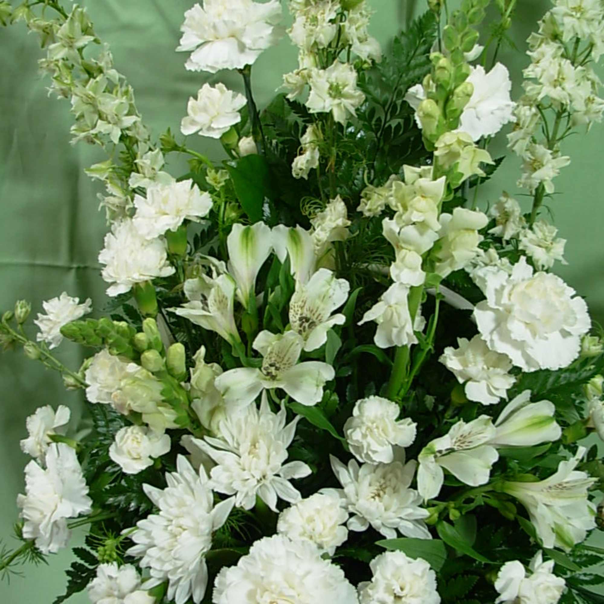 Our ETERNAL SYMPATHY arrangement is made in a white wicker basket with
