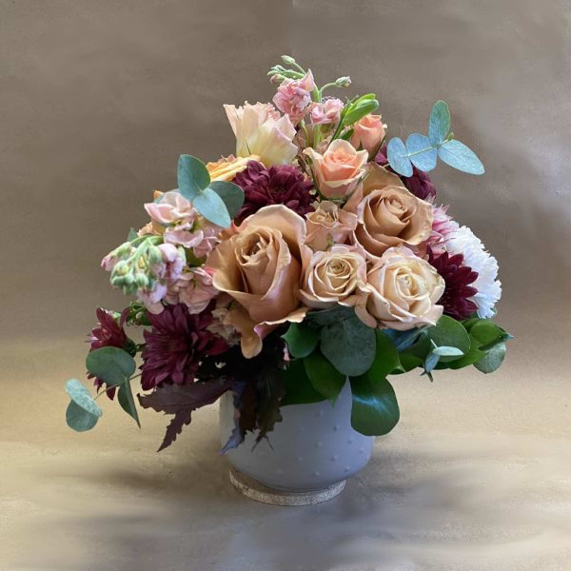 A glorious symphony of warm peach, soft pink, and burgundy with contrasting