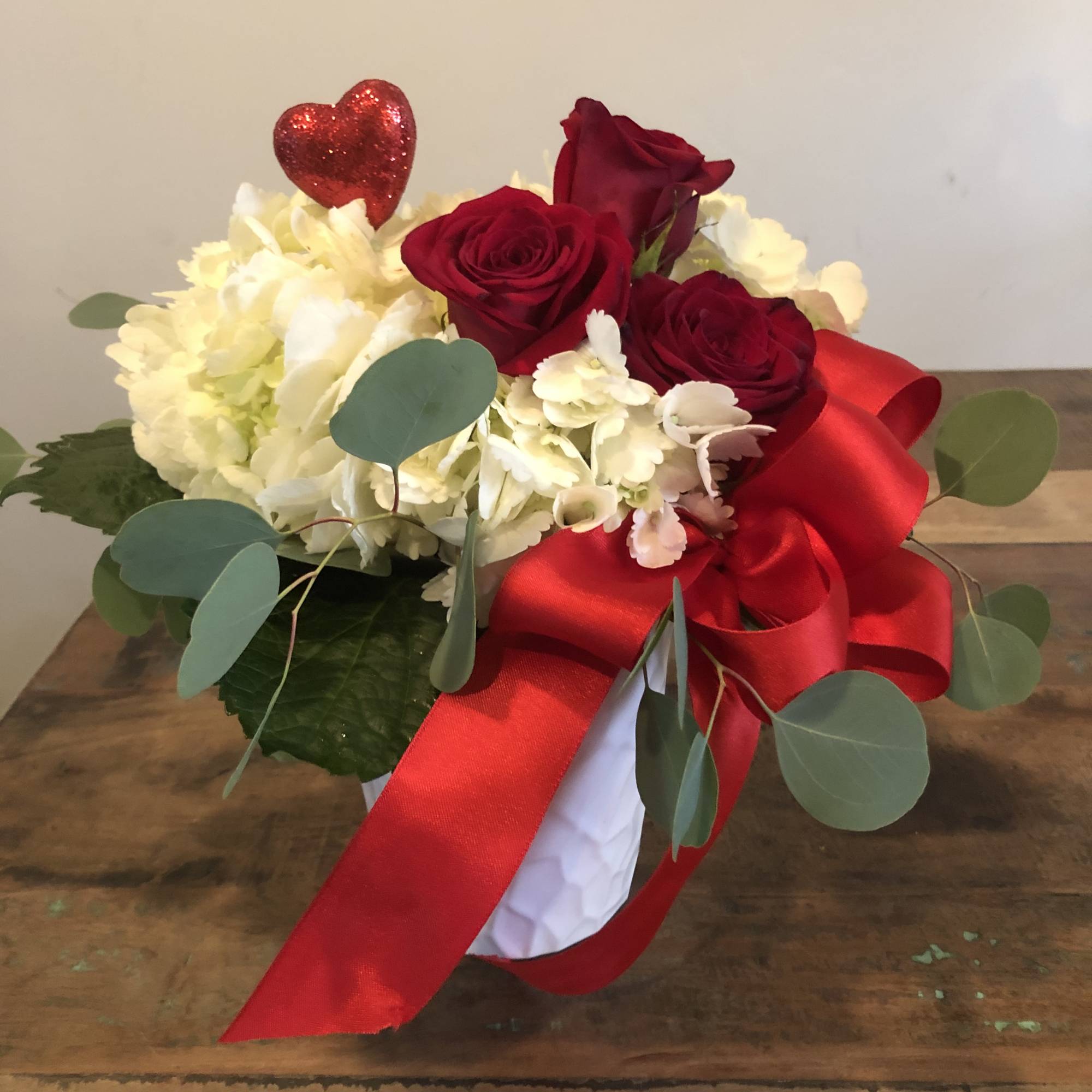 White hydrangea, red roses, assorted greenery
