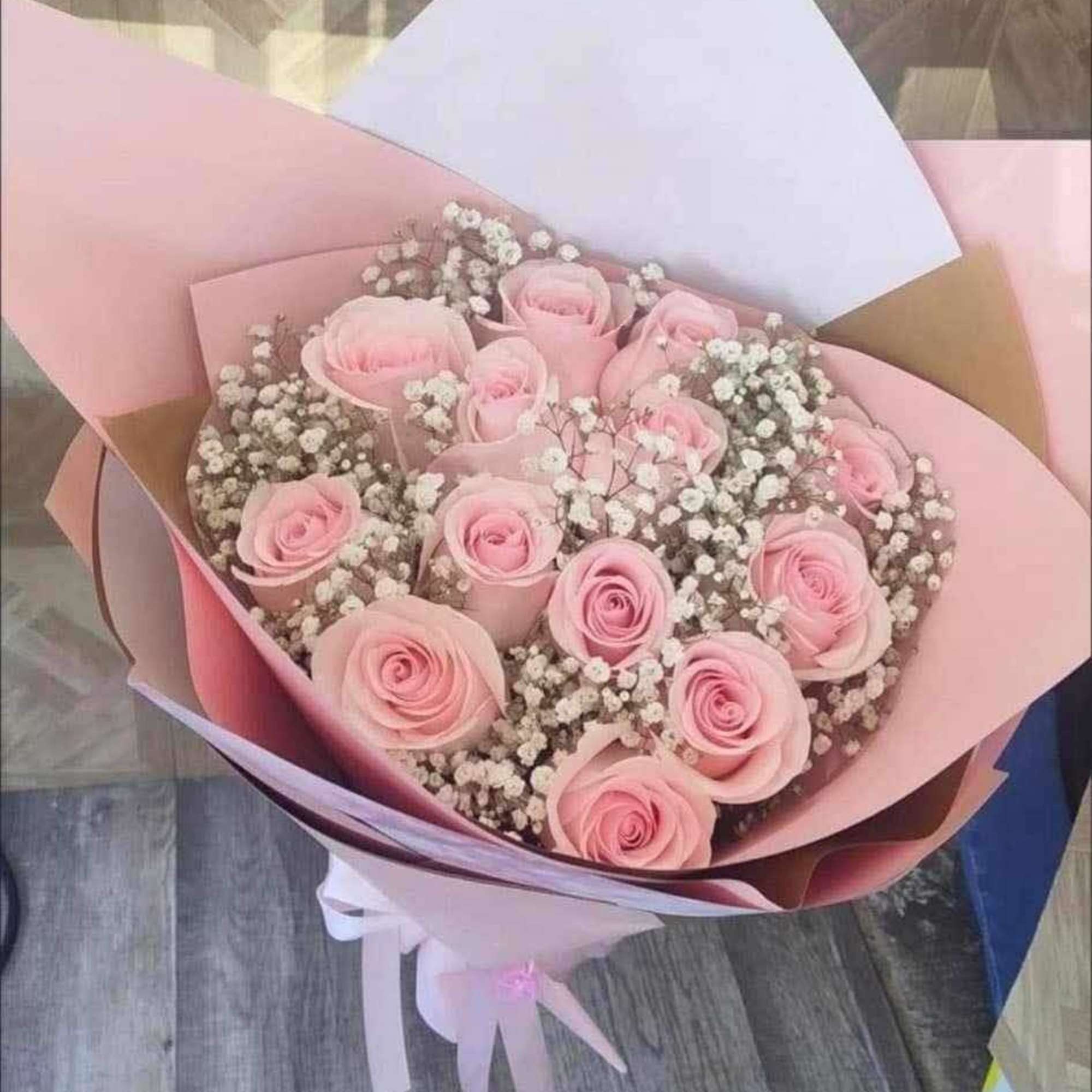 Dozen roses with babys breath in a bouquet. 
Can be any color