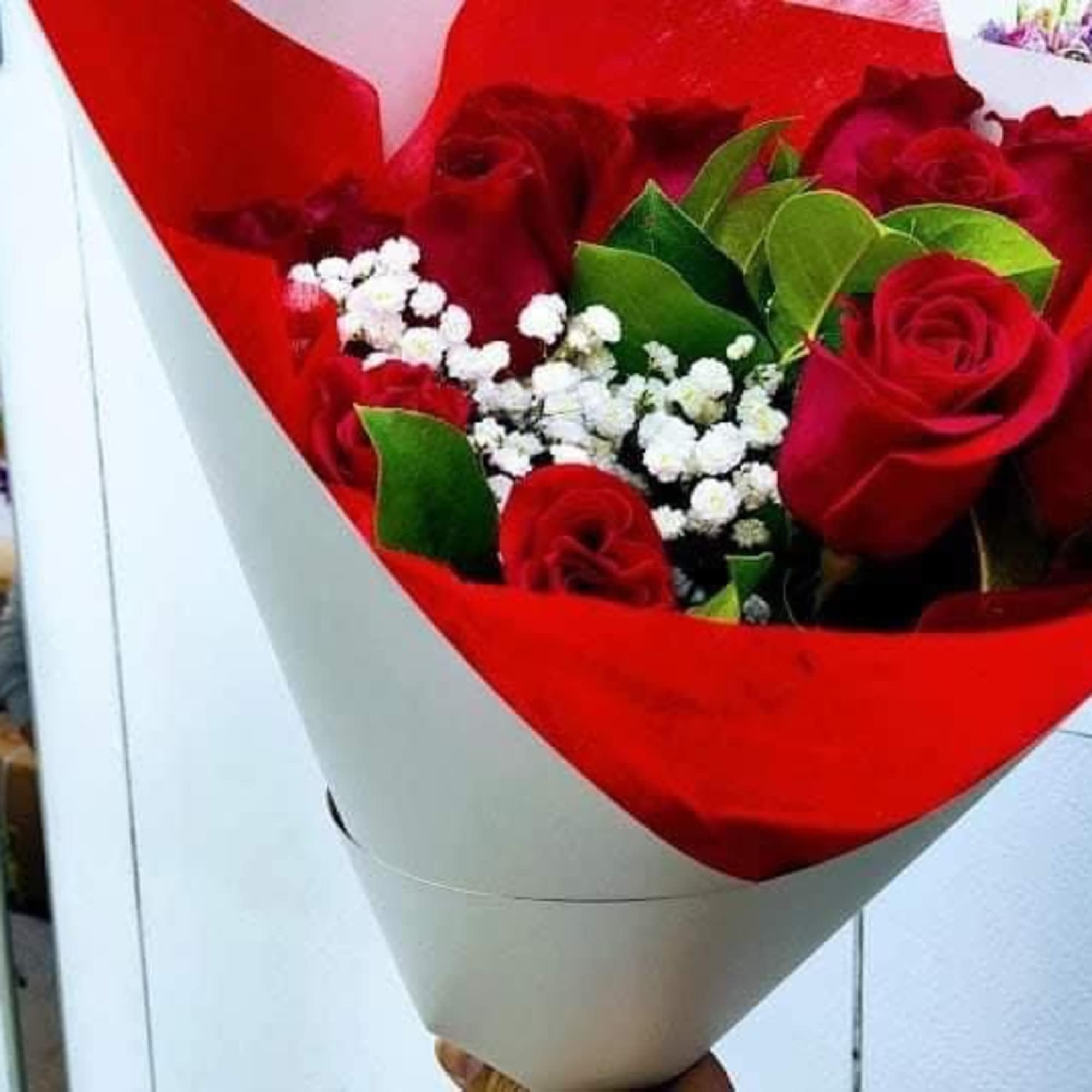 Dozen roses with babys breath in a bouquet. 
Can be any color