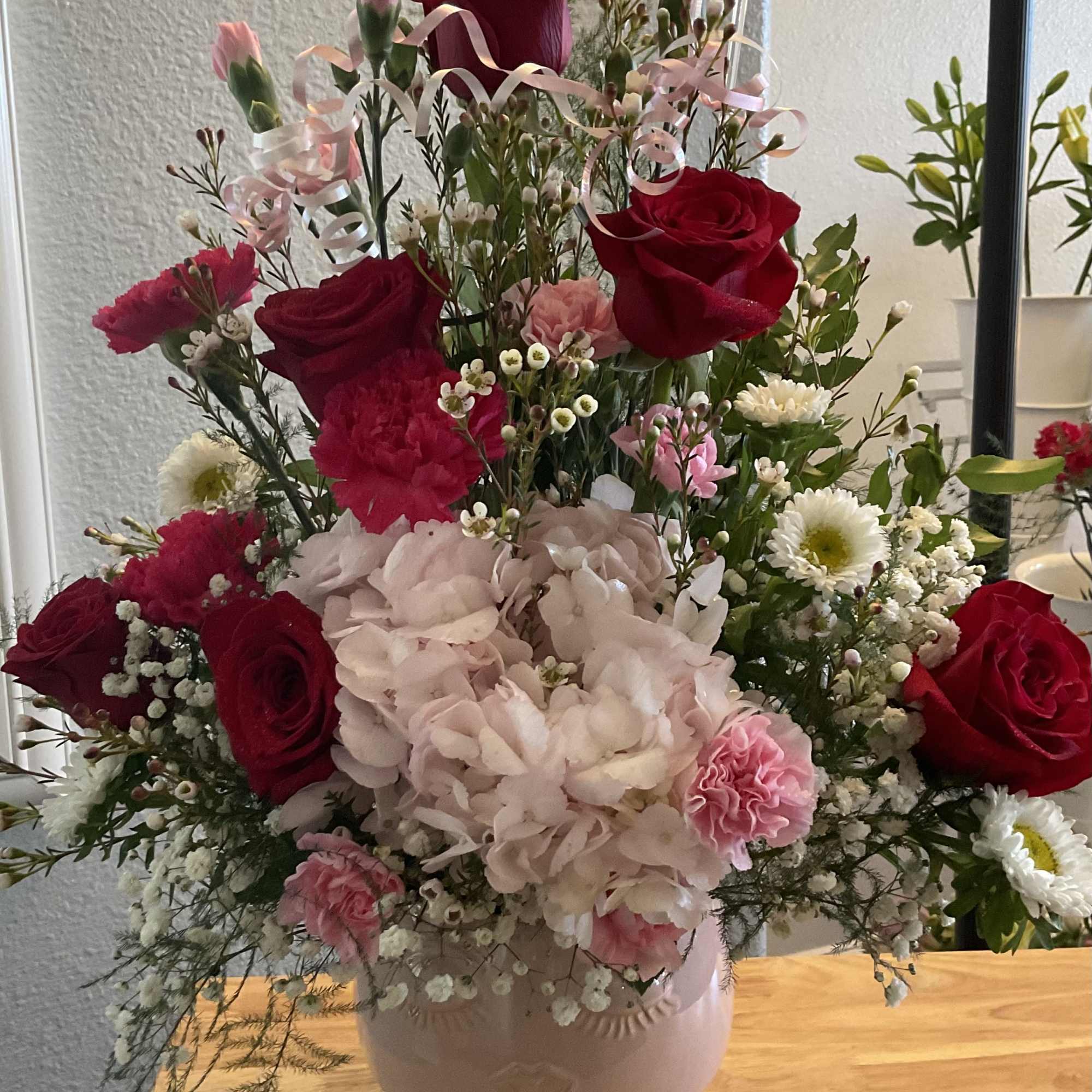 Pink and red bouquet in a ceramic head vase.
Pink head vase is