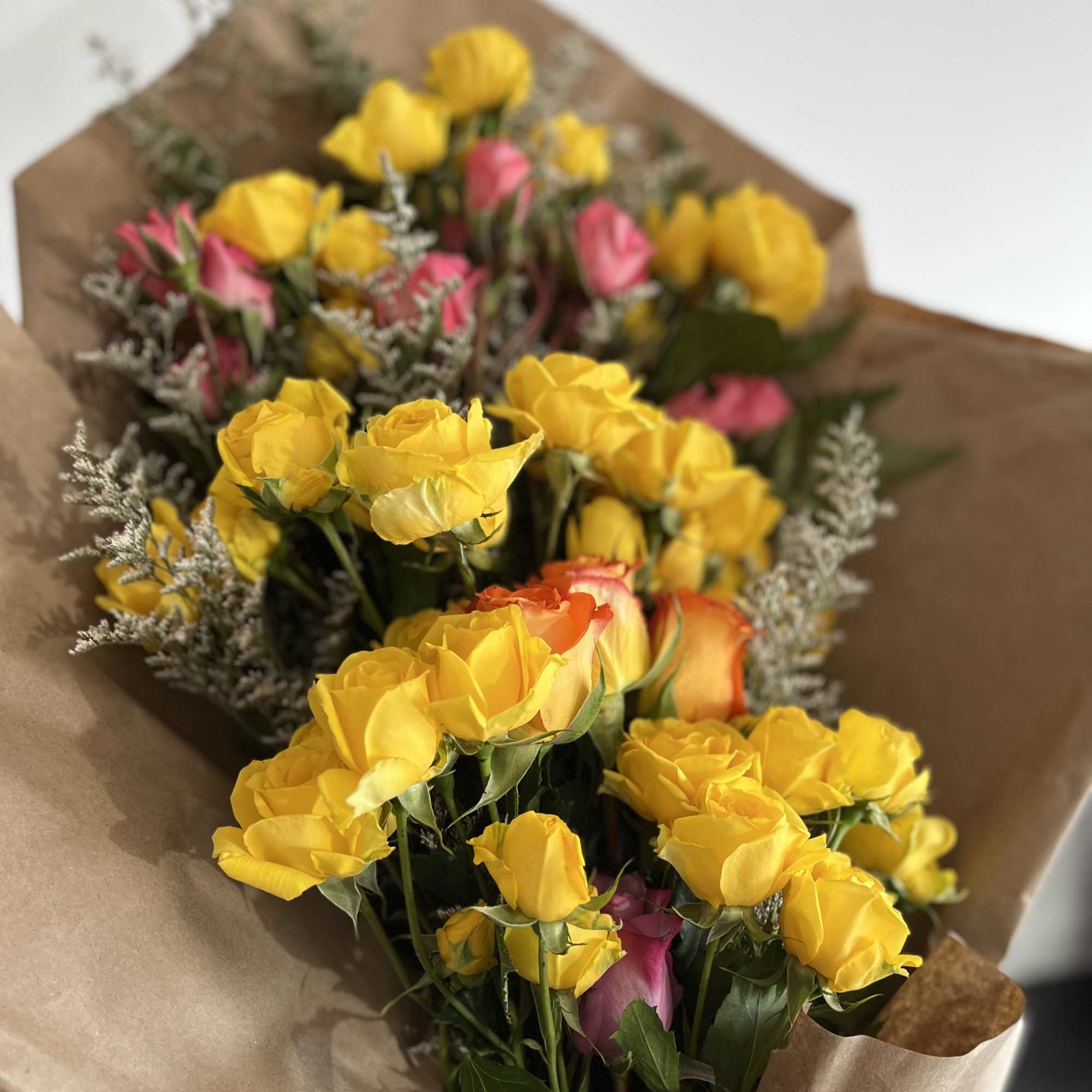 Wrapped Spray Rose bouquet with yellow spray roses, pops of pink and