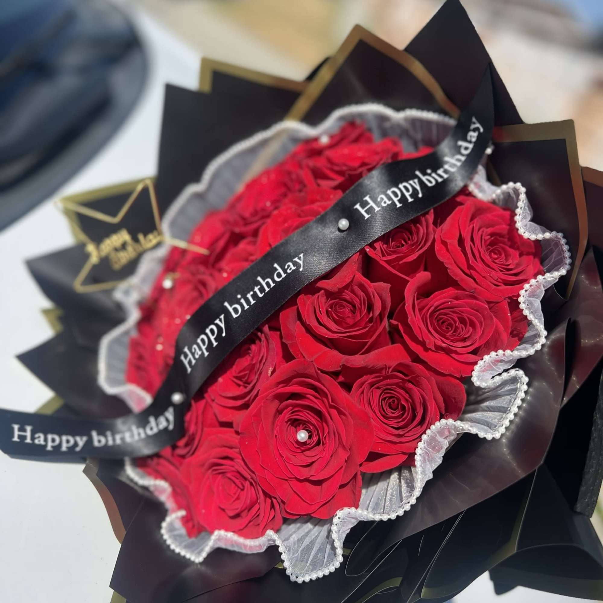 Bouquet of 24 red roses, ribbon and small sign included.