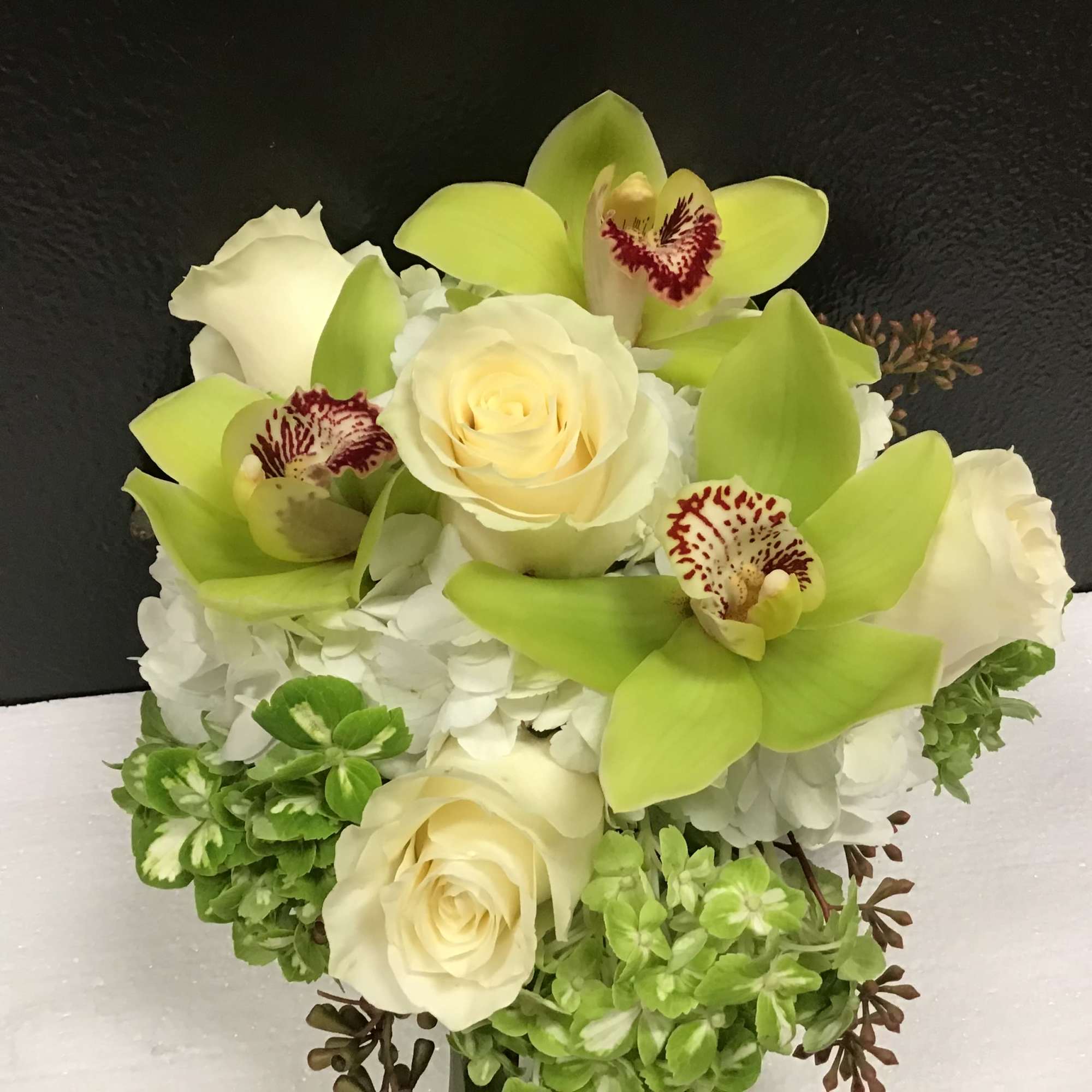 This beautiful and elegant arrangement make with hydrangea, roses and Cymbidium orchid
