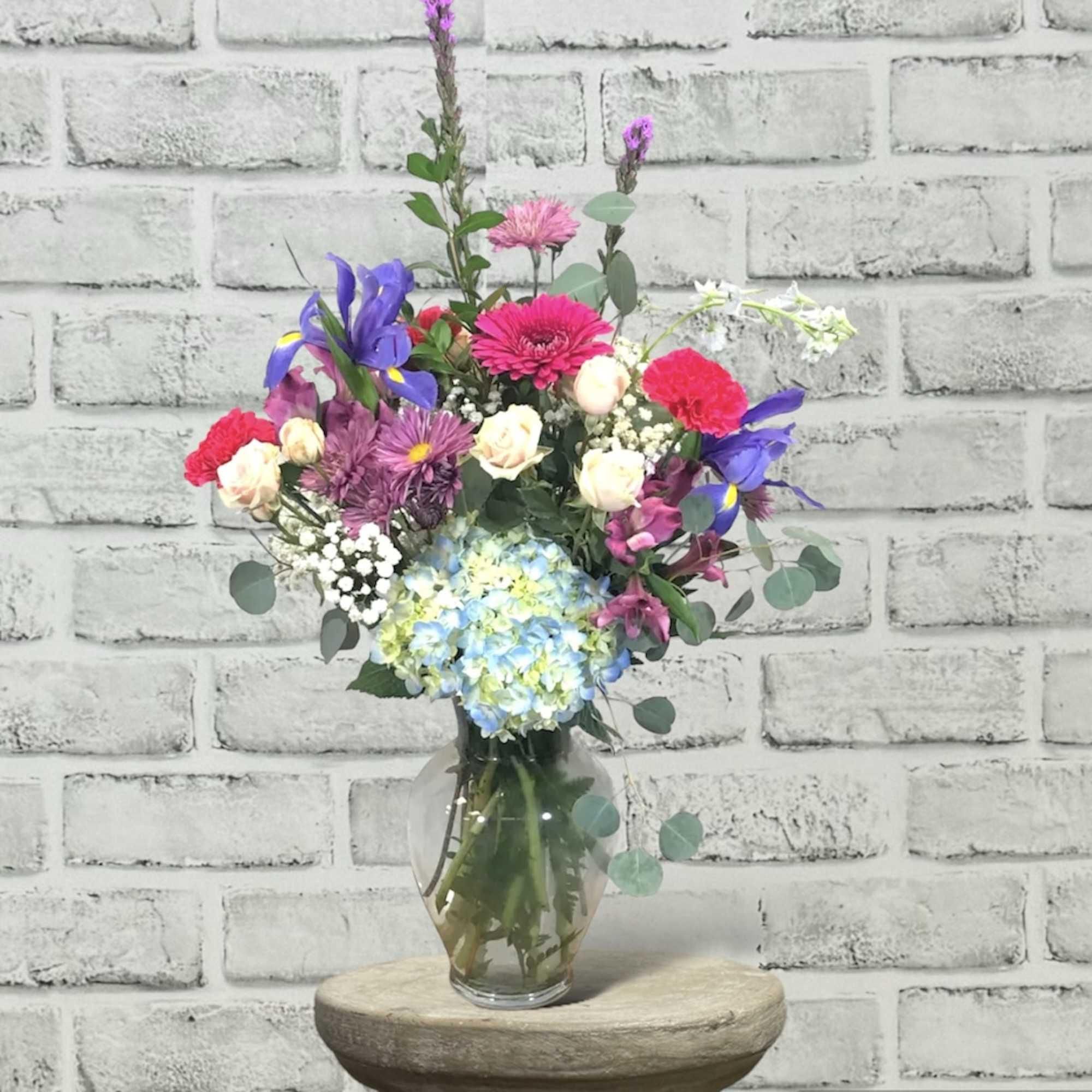 This traditional design in a vase has beautiful flowers in colors of