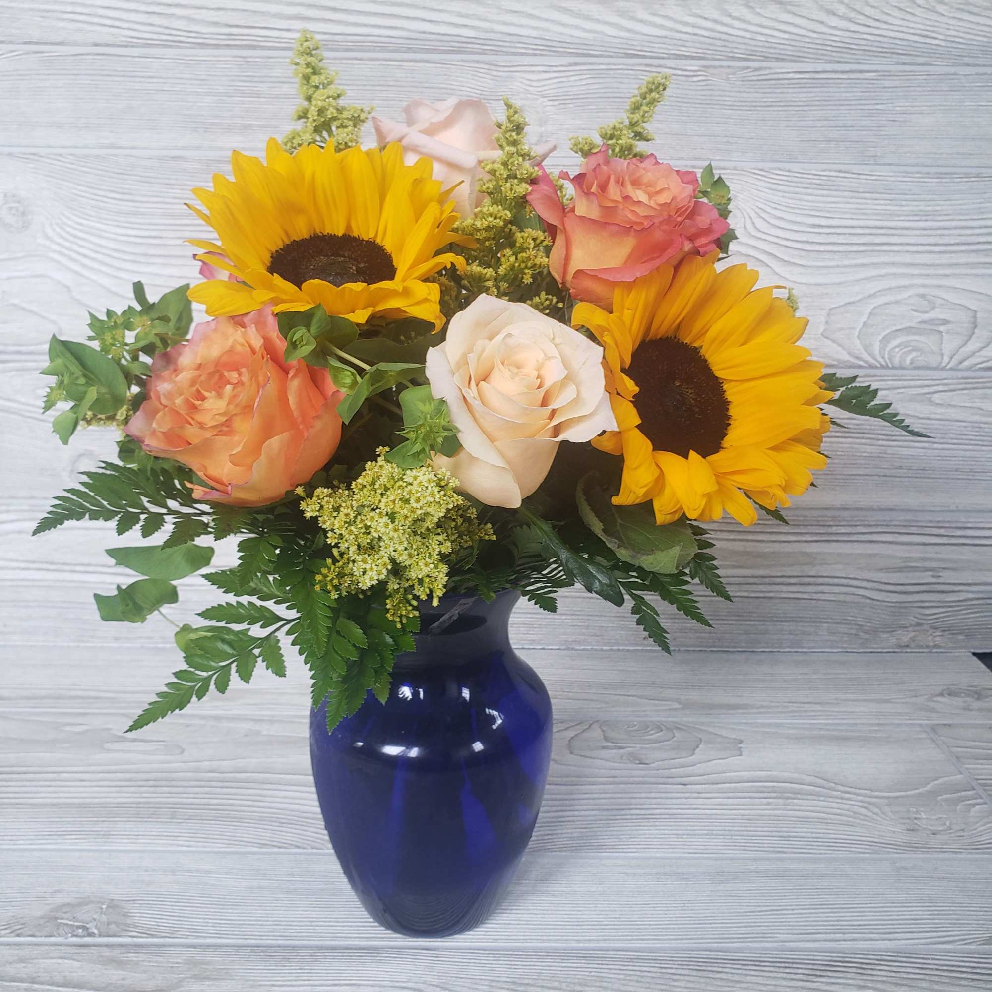 Sunflowers, Roses, Filler in a beautiful cobalt blue vase.  Sunflowers, Roses, Filler in a beautiful cobalt blue vase.