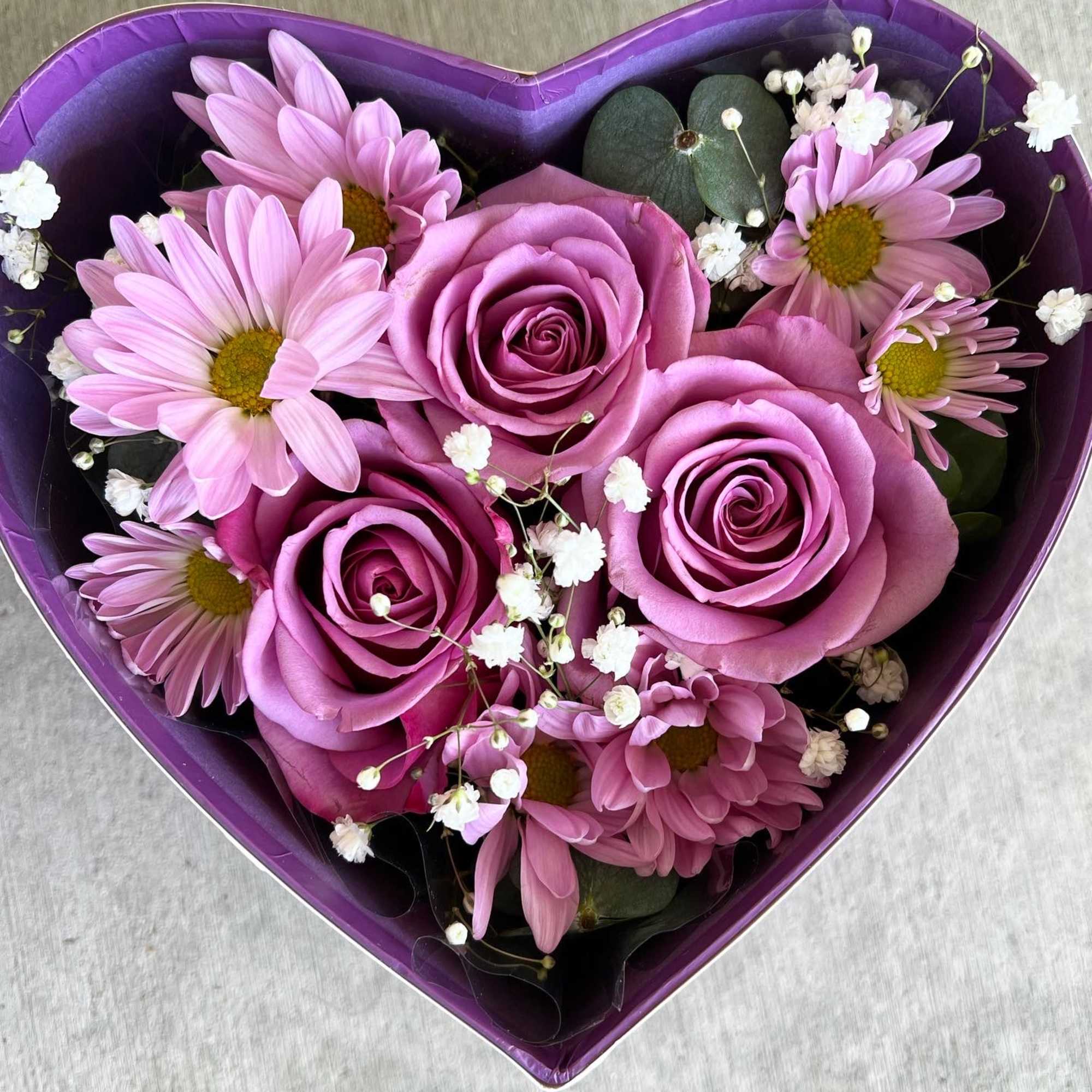 pink/lavender/purple flowers arranged inside a heart shape box with butterflies on the